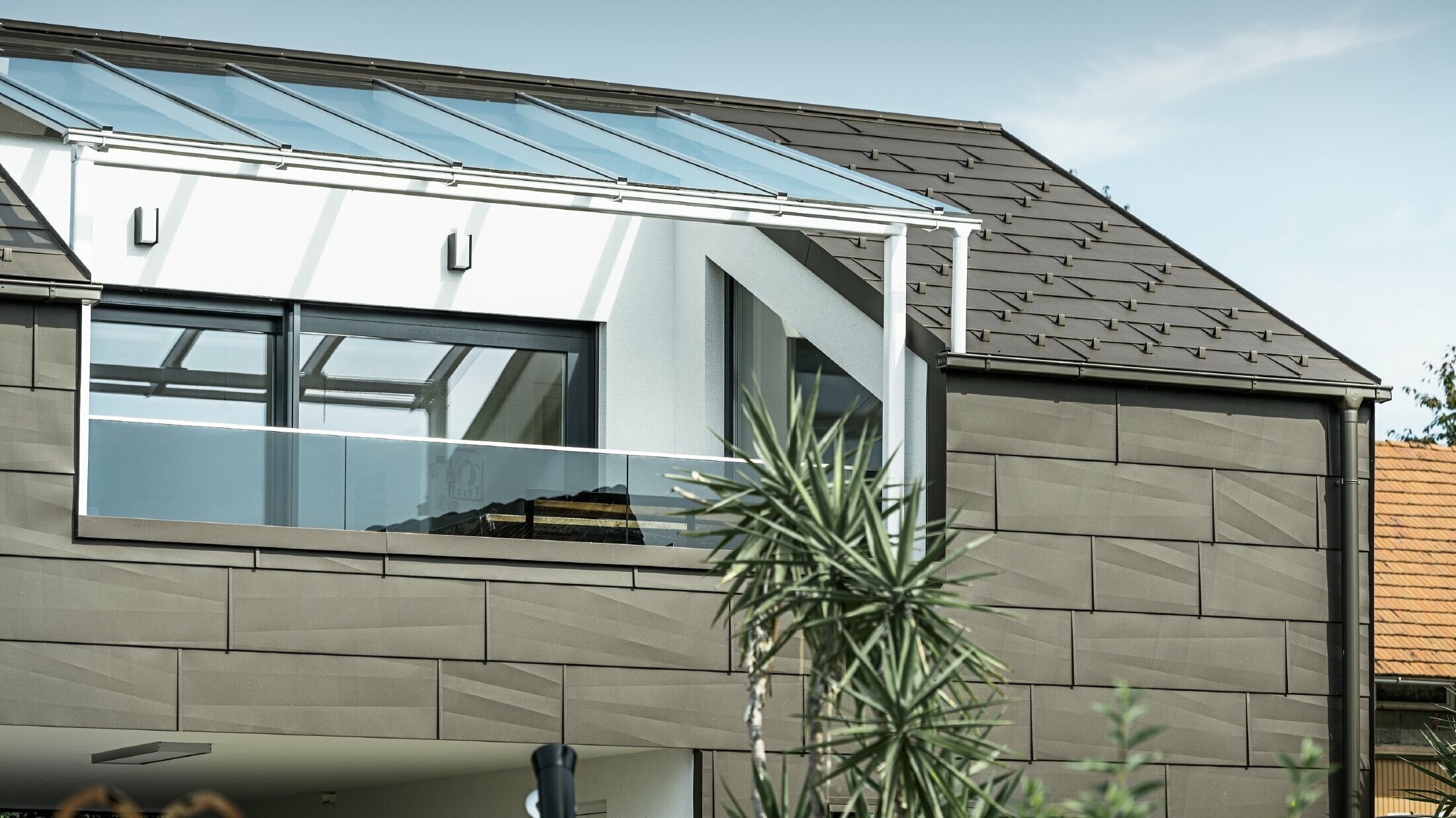 Extension with a roof terrace clad with the PREFA complete system, while the PREFA roof and façade panel FX.12 was used on the roof and façade. In addition, the PREFA box gutter with the PREFA downpipe and the extensive range of accessories in brown are used for roof drainage.