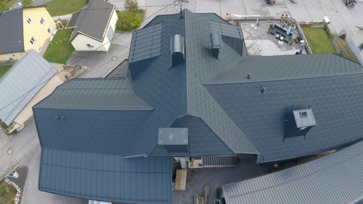Renovation of a large roof area with many details – channels, dormers and chimneys. The roof has been covered with PREFA R.16 roof tiles in anthracite.