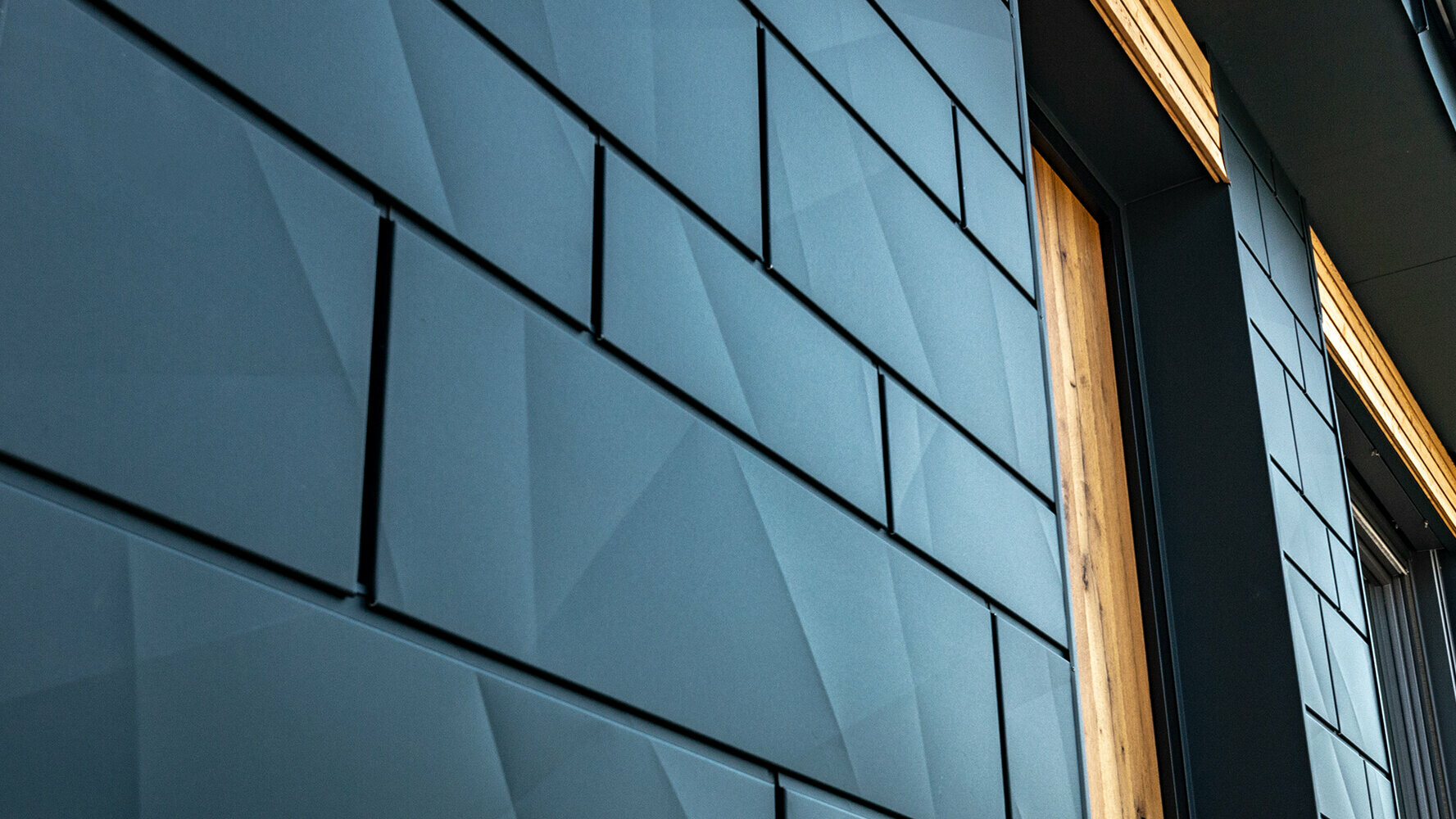 PREFA façade panels with buckled appearance; PREFA aluminium Siding.X  in anthracite combined with wood façade.