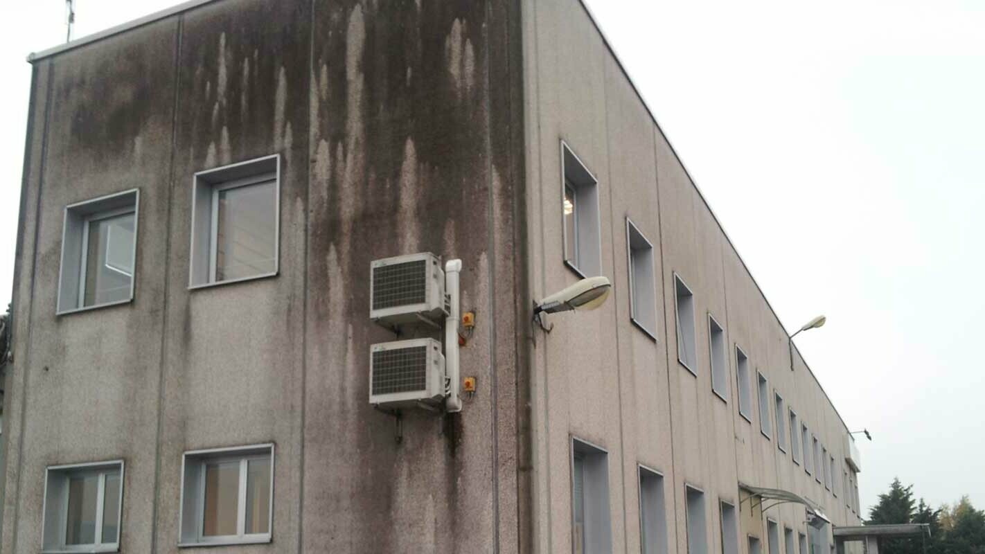 Old industrial building before renovation of façade with PREFA sidings; strong discolouration and soiling on the façade