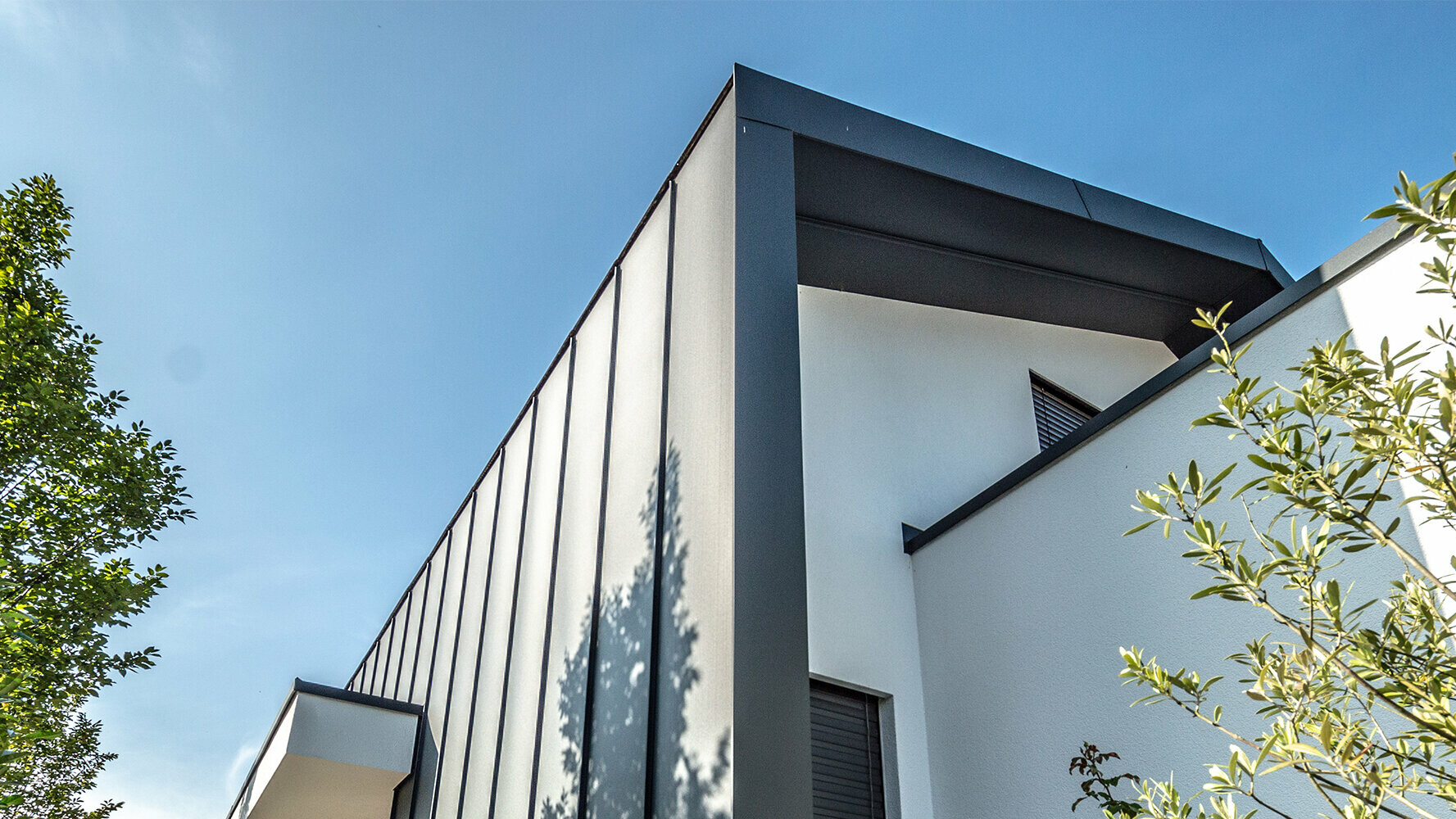 Modern detached house with white plaster façade and standing seam roof and  façade with Prefalz from PREFA in anthracite