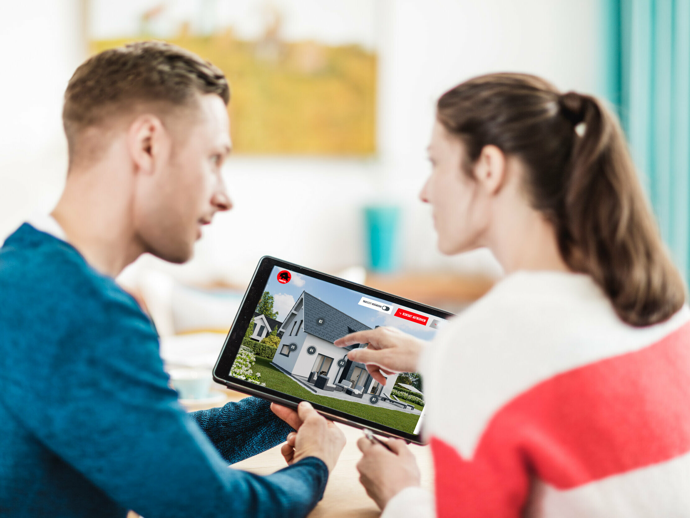 A couple is holding a tablet with the PREFA roof & façade configurator displayed on it.