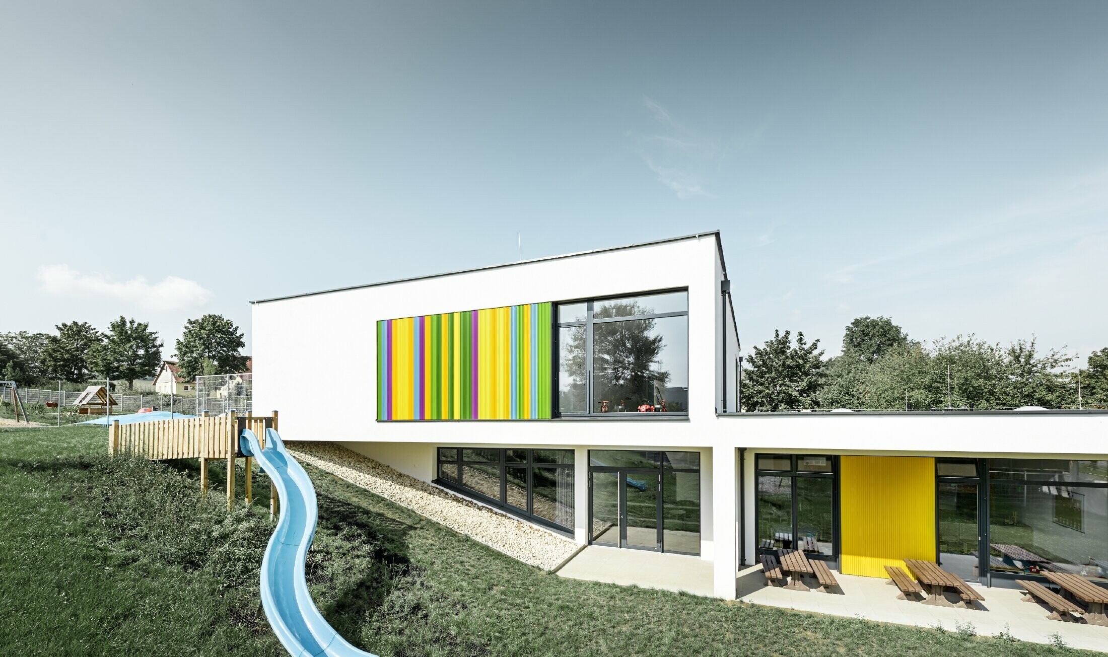 Rear view of the kindergarten in Hargelsberg with the colourful PREFA zig-zag profile in the colours yellow, green, purple and blue