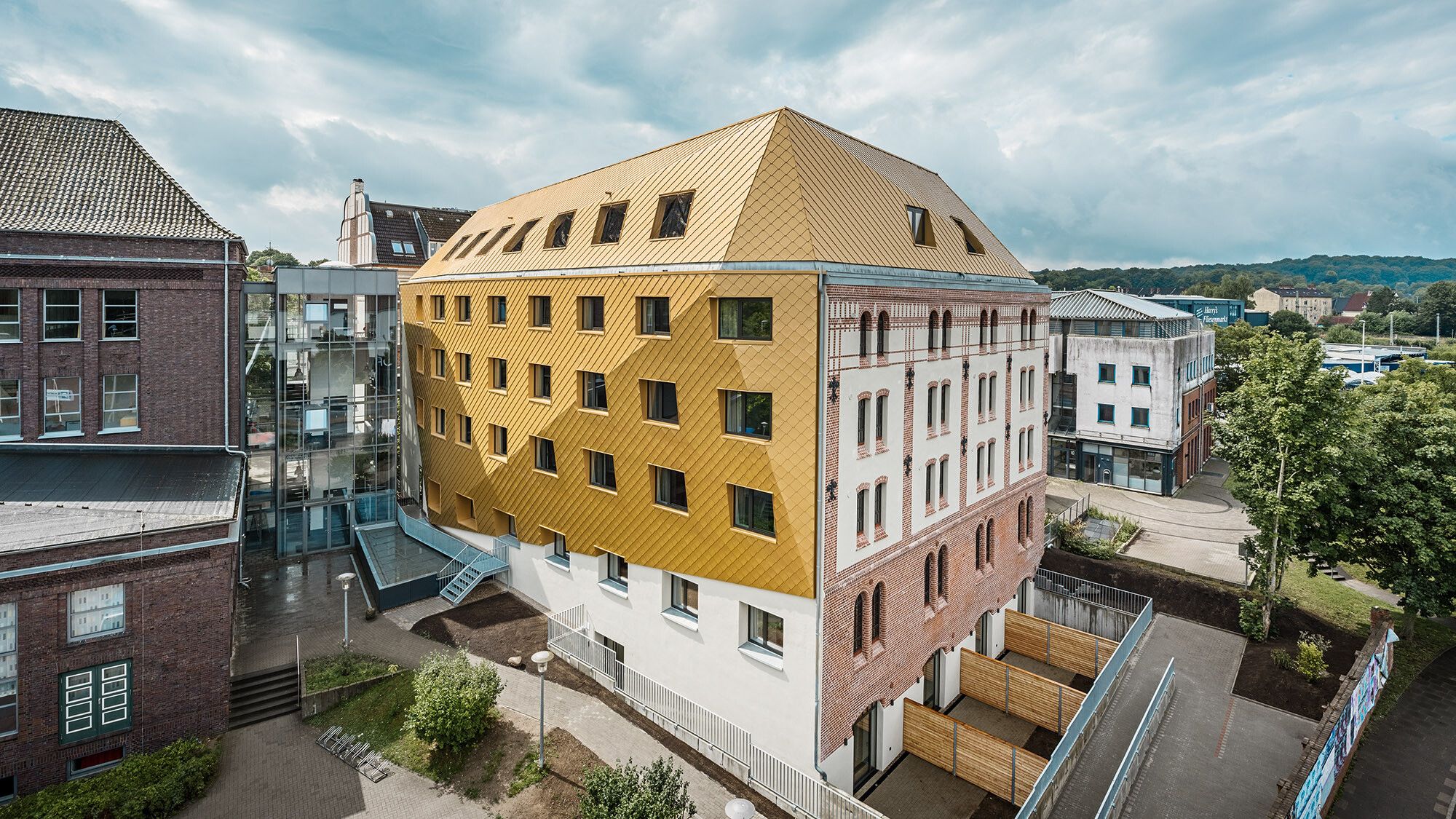 The new student residence from a bird's eye view from the side, the folded envelope wrapping around the upper area of the building.