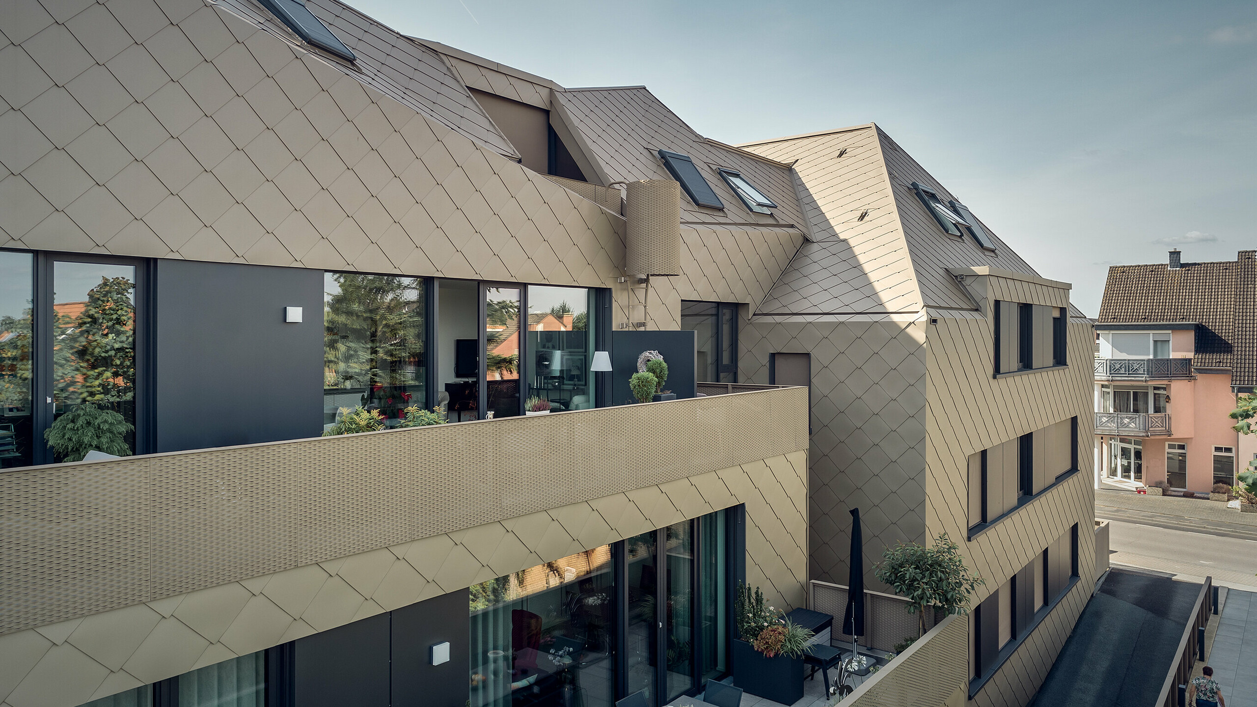 A side view shows the crystalline roof shape and the rhomboid-shaped design of the Prefa solutions