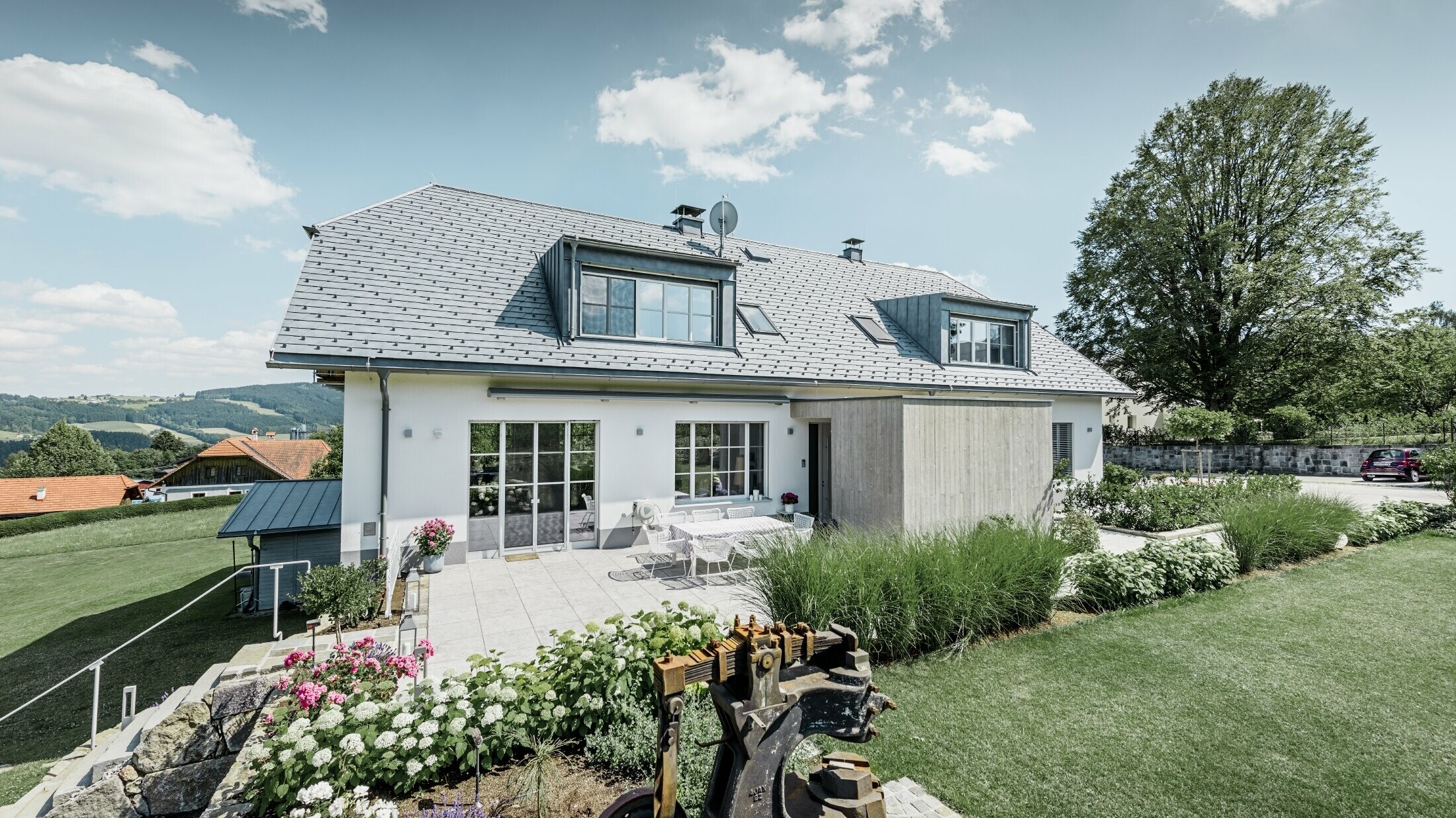 Classic detached house with a half-hipped roof; the house sporting a roof renovation with PREFA roof shingles in stone grey, with beautifully landscaped garden and spacious terrace.