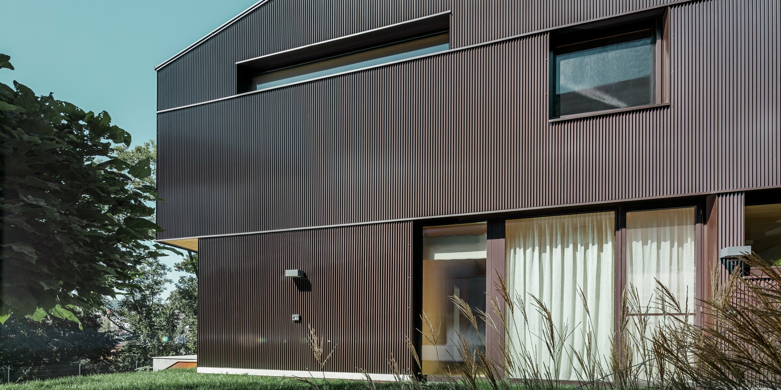 Modern detached house with PREFA zig-zag profile façade cladding in brown.