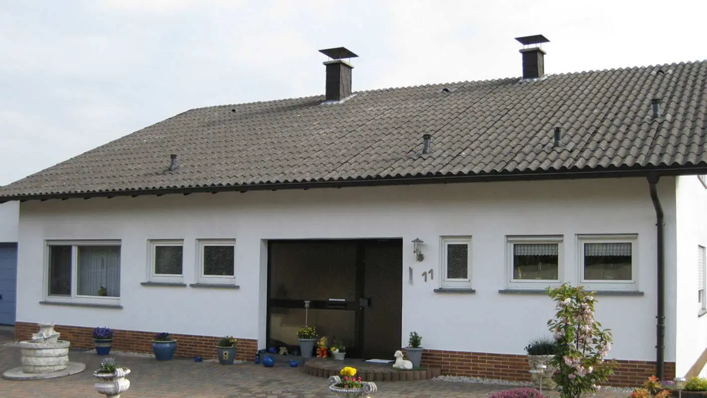 Detached house with corrugated fibre cement before roof renovation with PREFA roof tiles