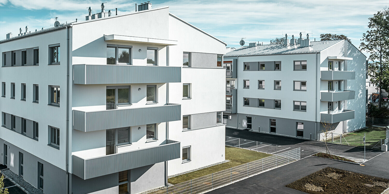 Modern apartment complex with white façade and balconies with PREFA serrated profile in metallic silver
