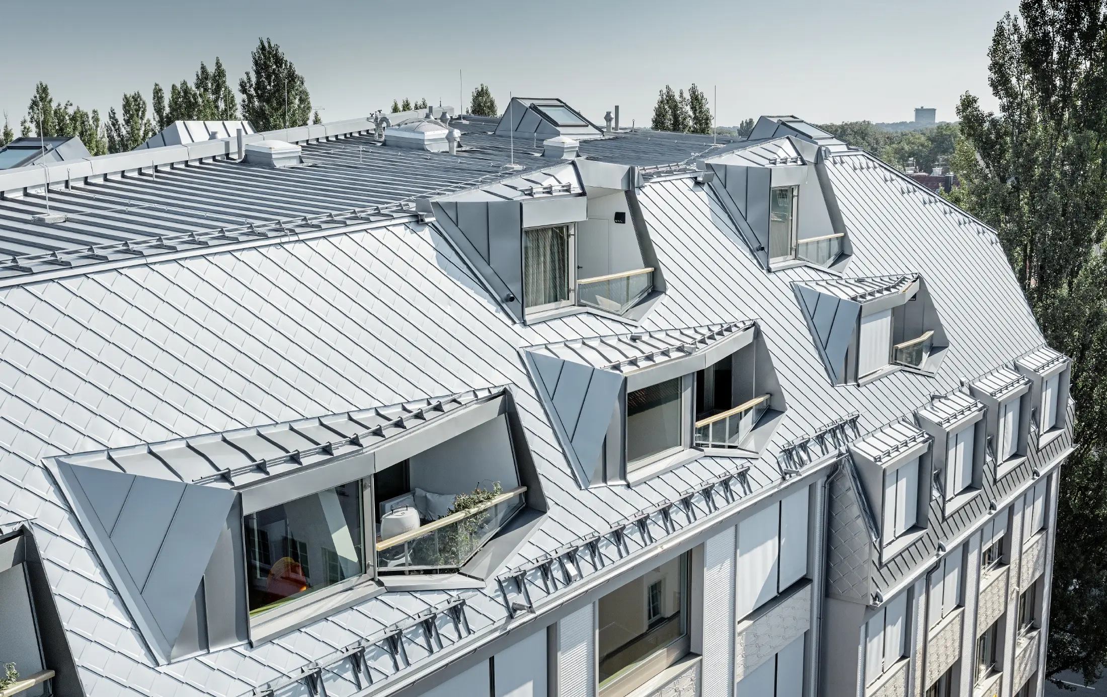 Renovated mansard apartments with large, open galleries in a residential and commercial building in Leopoldstraße/corner of Hohenzollernstraße in Munich (Germany), with a roof covering made of PREFA rhomboid roof tiles