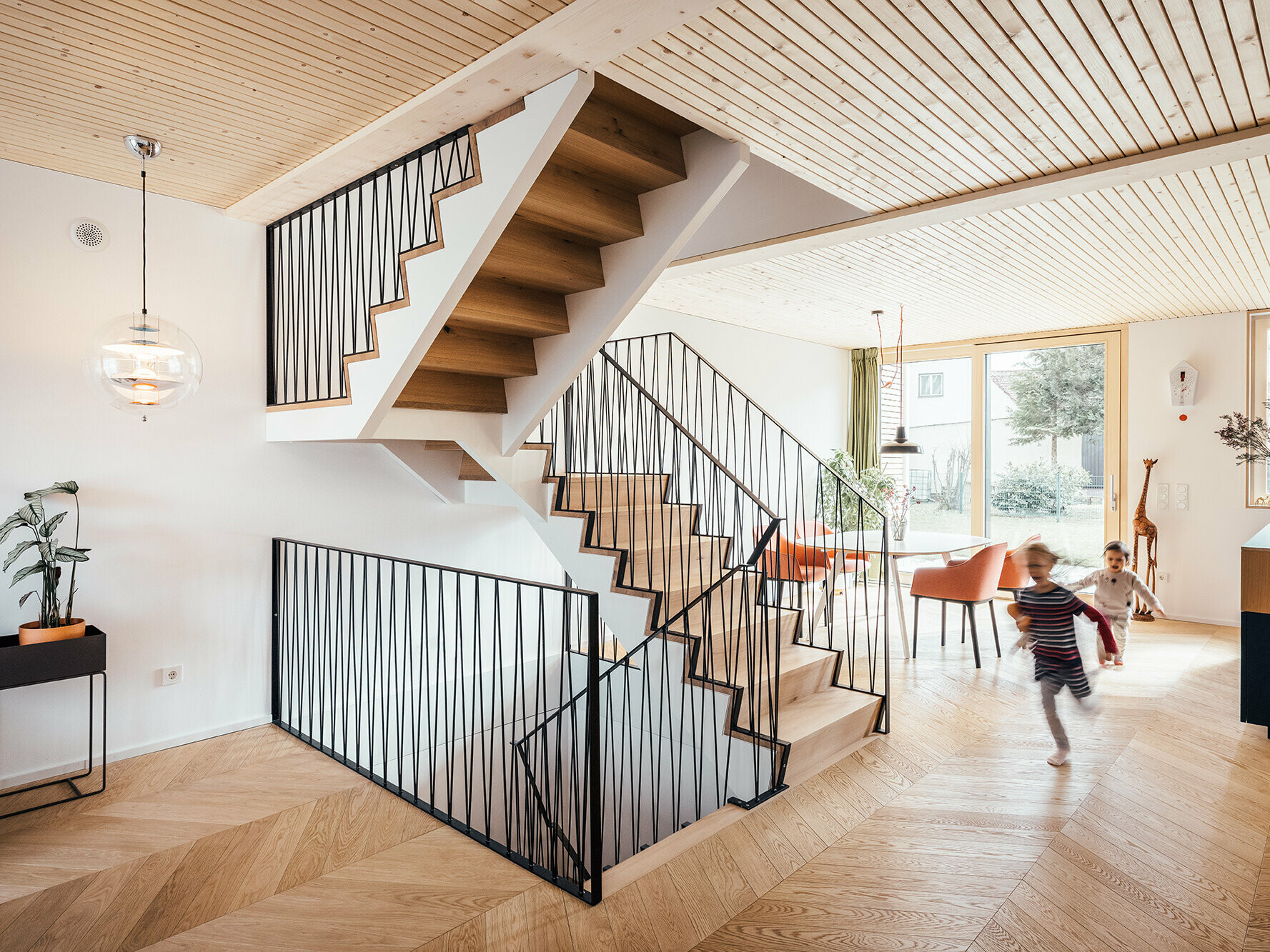 Interior of House West, colour interplay: white walls, herringbone parquet flooring in oak, exposed wood ceiling in spruce.