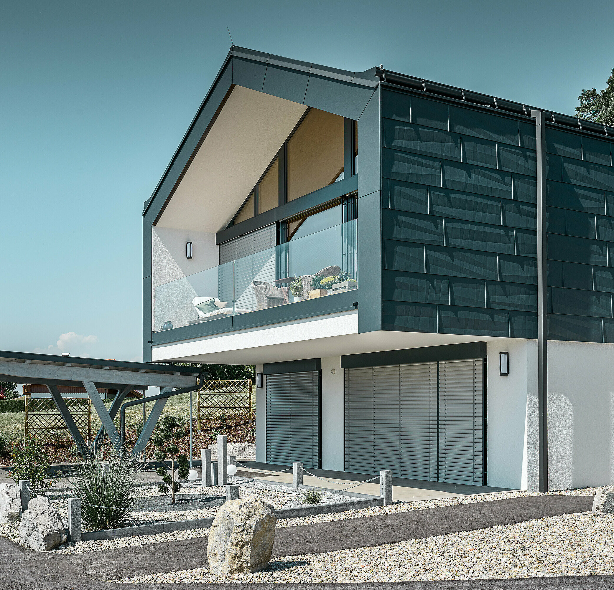 Façade cladding on the top floor using PREFA FX.12 façade panels in P.10 anthracite. The robust PREFA square downpipe is used for drainage.