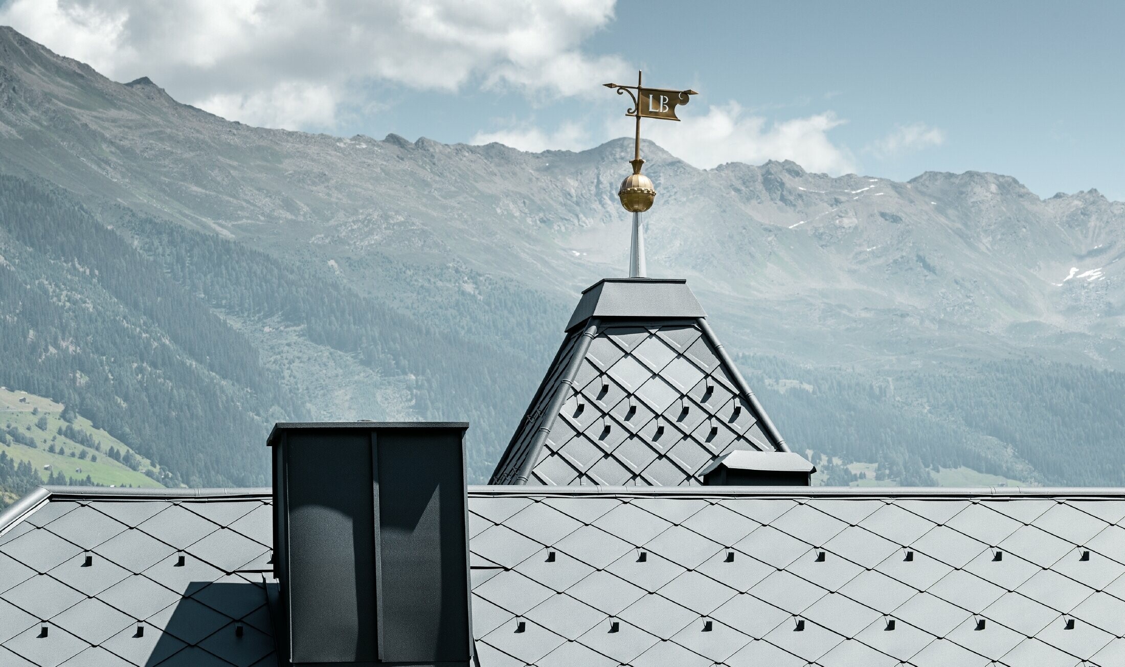 Rock cabin with a tower and an aluminium roof in anthracite with a Pizzeria on the ground floor