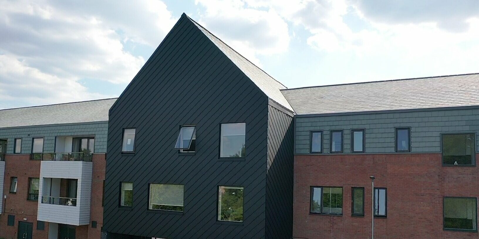 Entrance to the Courtyards wrapped in PREFA rhomoid tiles 29 × 29 in P.10 Black and Bricks