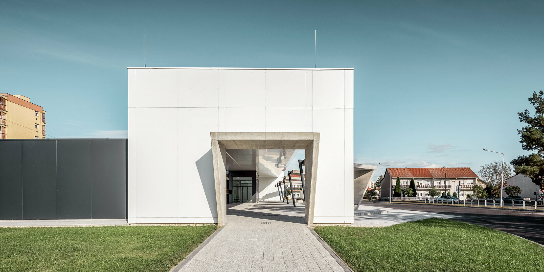 Lateral view of the railway station in Lenti, Hungary. A passageway to the bus stops is visible.