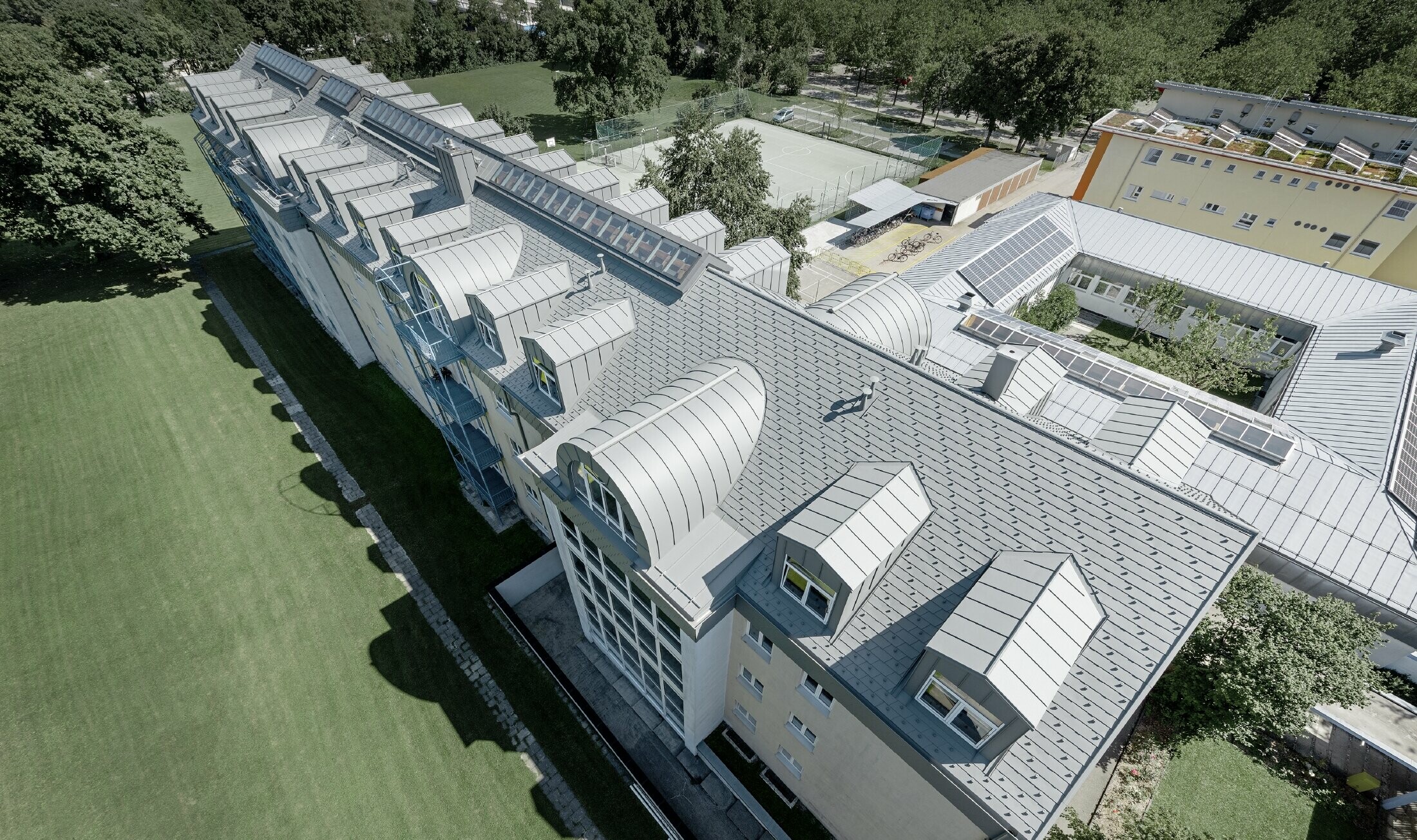 Top floor of the Albertinum building in Munich (Germany) with PREFA shingle and standing seam in light grey