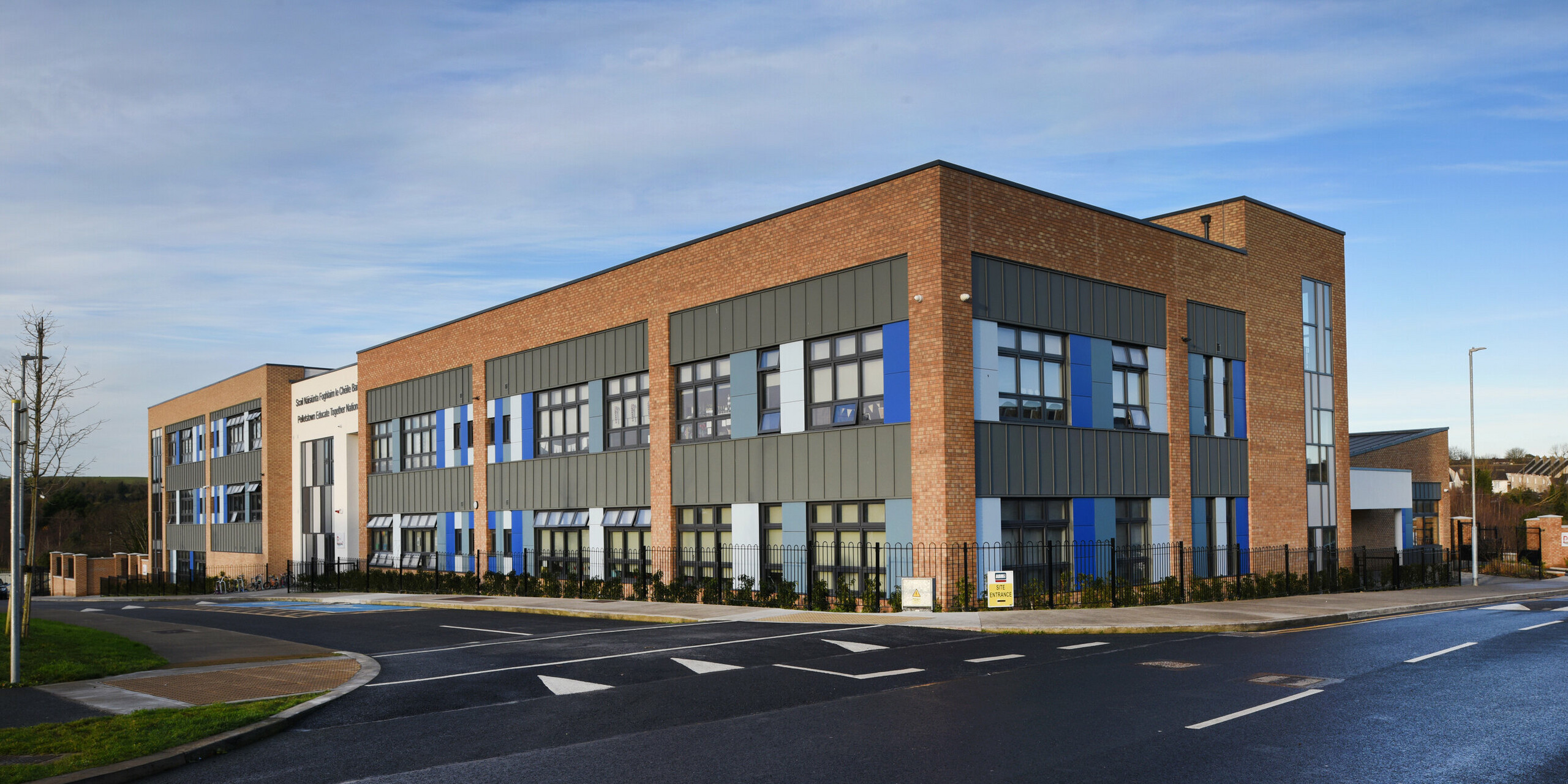 Side view of the Pelletstown Educate Together National School in Dublin, Republic of Ireland. The light grey PREFALZ standing seam cladding forms an elegant and weather-resistant outer skin. The aluminium elements ensure a harmonious transition to the clinker brick and rendered façades - a unique mix of materials.