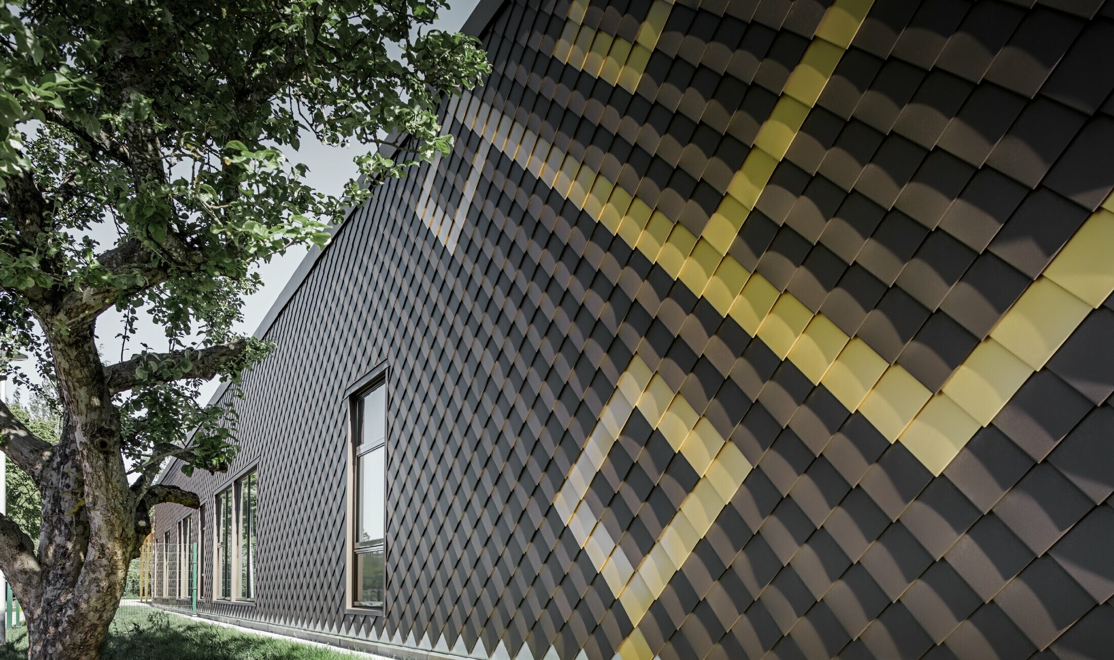 PREFA rhomboid tiles were used for the façade of the nursery school in Stockholm. The exterior façade is beautifully designed in brown and Mayan gold.
