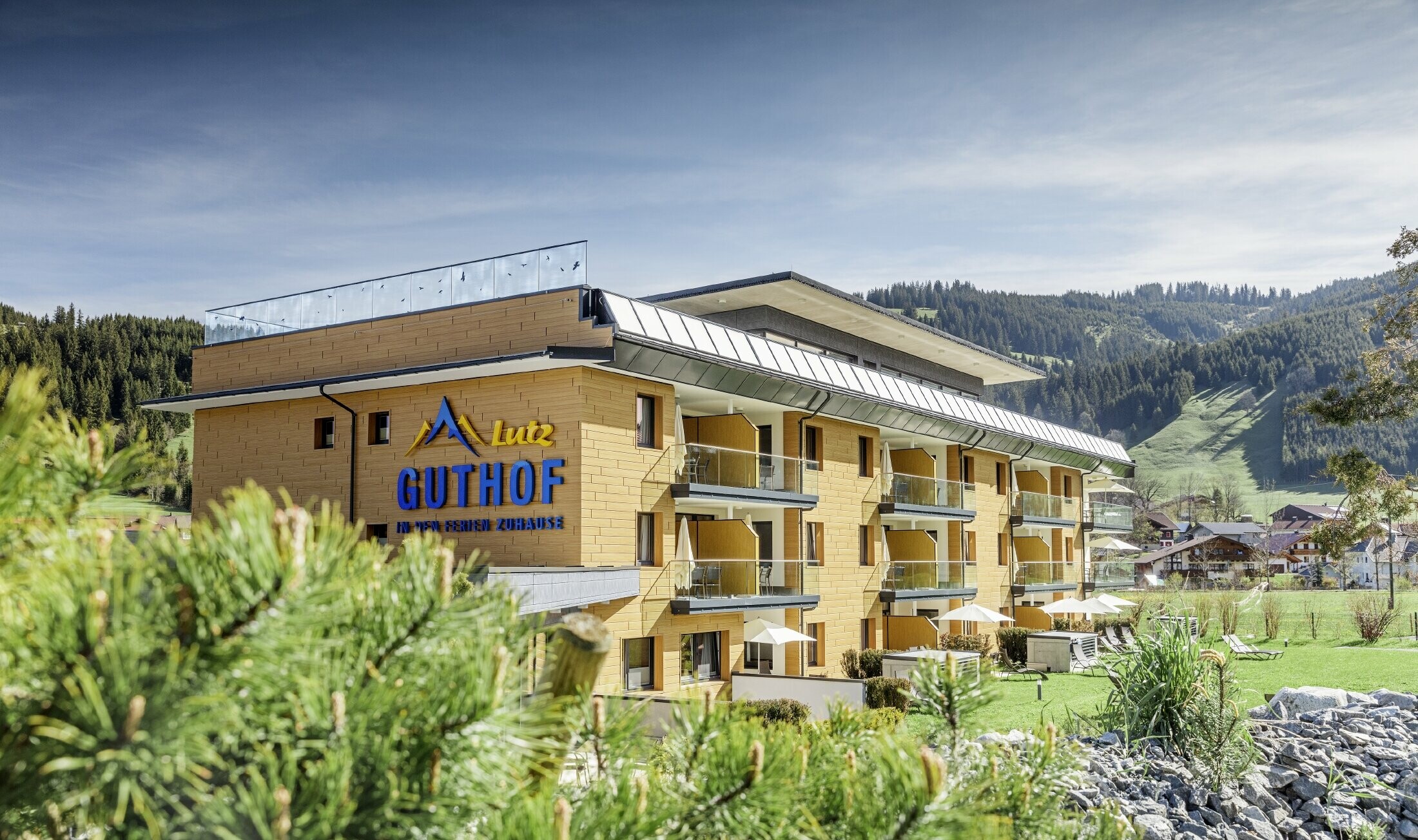 The Guthof Lutz, surrounded by nature, was clad in the PREFA natural oak sidings. The logo of the holiday apartments is displayed on the façade.