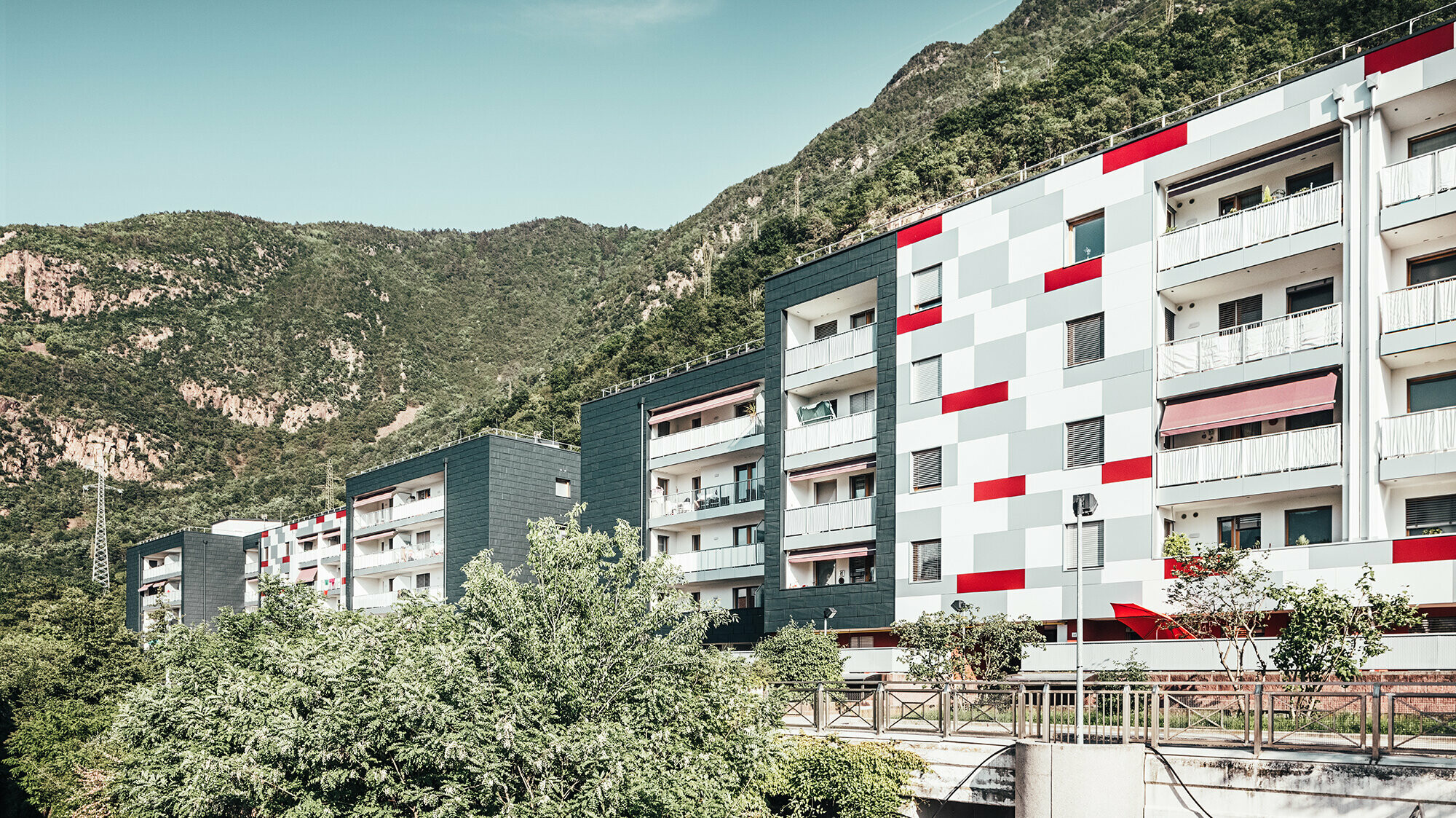 The result of the thermal refurbishment on Köstenweg: on the left, the anthracite-coloured PREFA façade panels, on the right, white, grey and red façade surfaces.