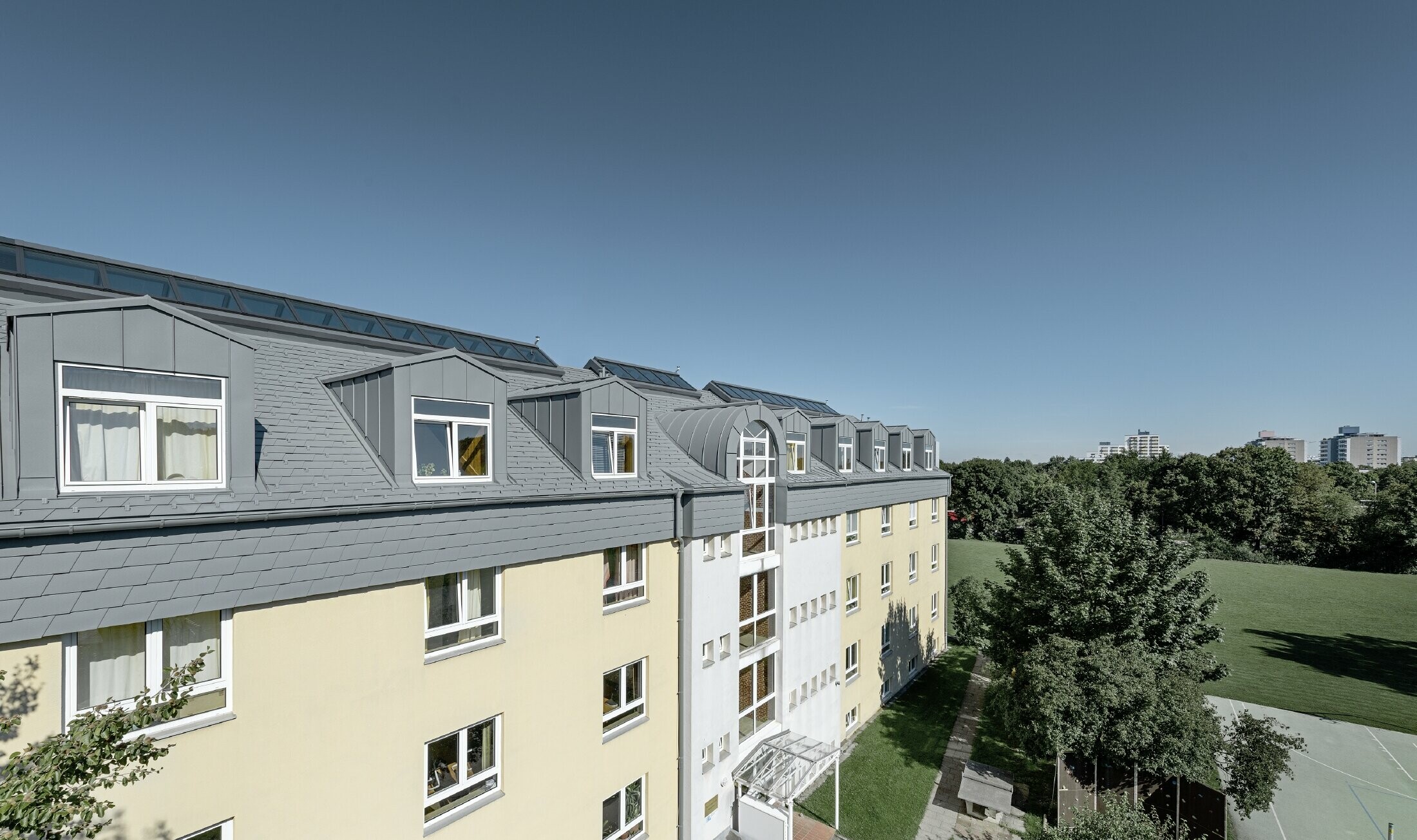 Top floor of the Albertinum building in Munich (Germany) with PREFA shingle and standing seam in light grey