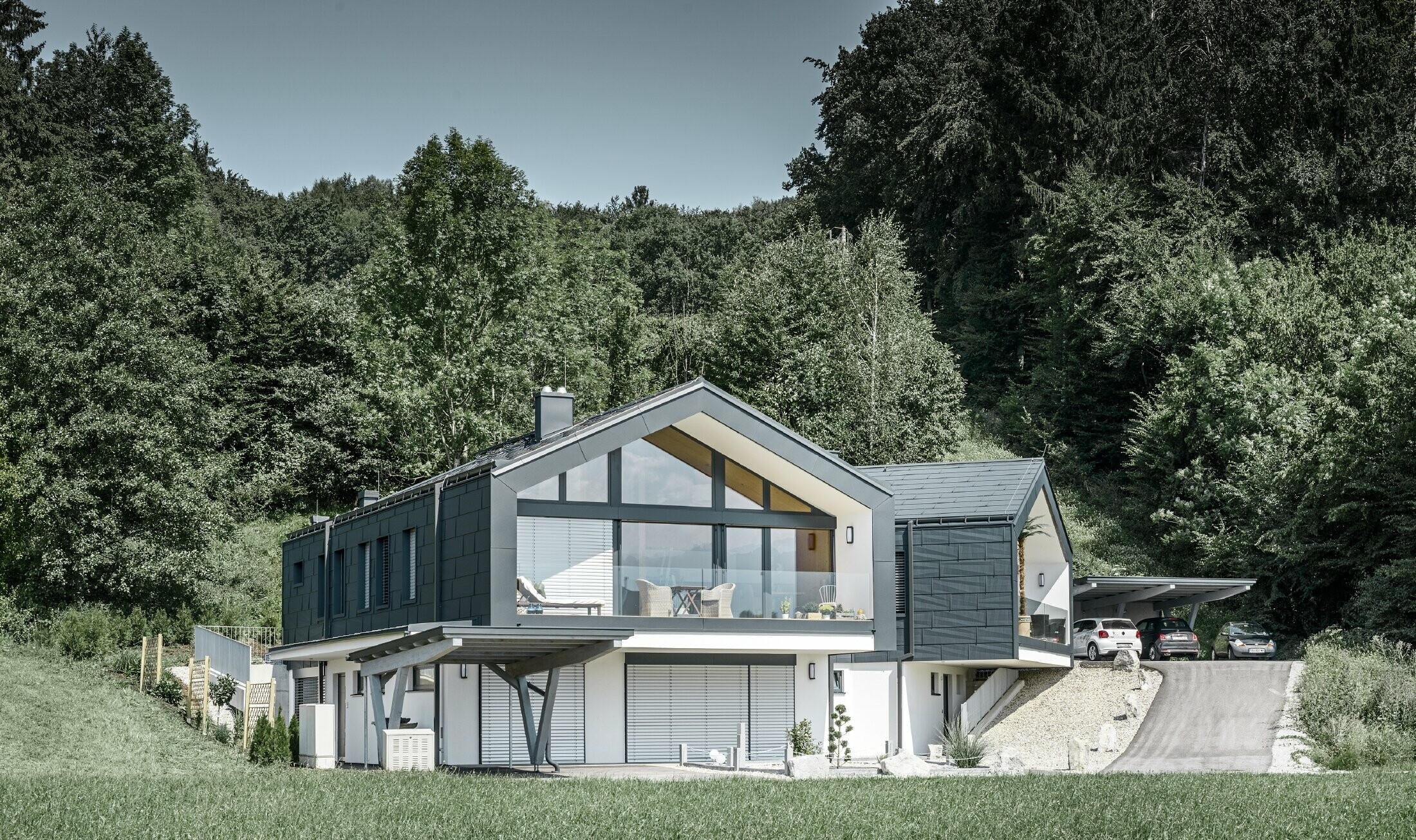 Modern apartment building with a large glazed front, and roof and façade clad with PREFA FX.12 roof and façade panels in anthracite