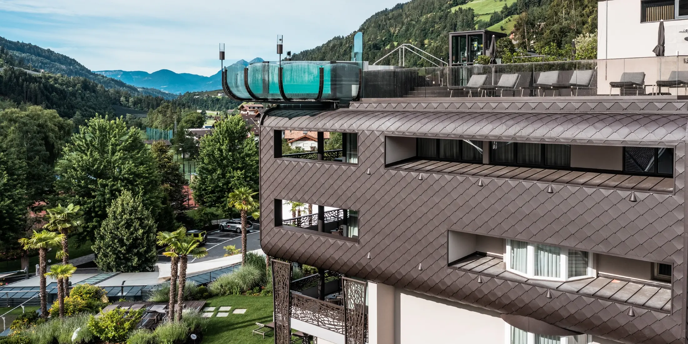 Neben den PREFA-Fassadenschindeln sticht der beeindruckende Pool des Hotelbereichs hervor.