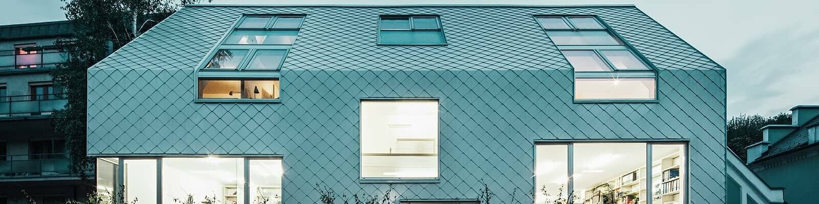 Outside view of the Superblock. The façade and roof are covered with PREFA rhomboid tiles in the colour white