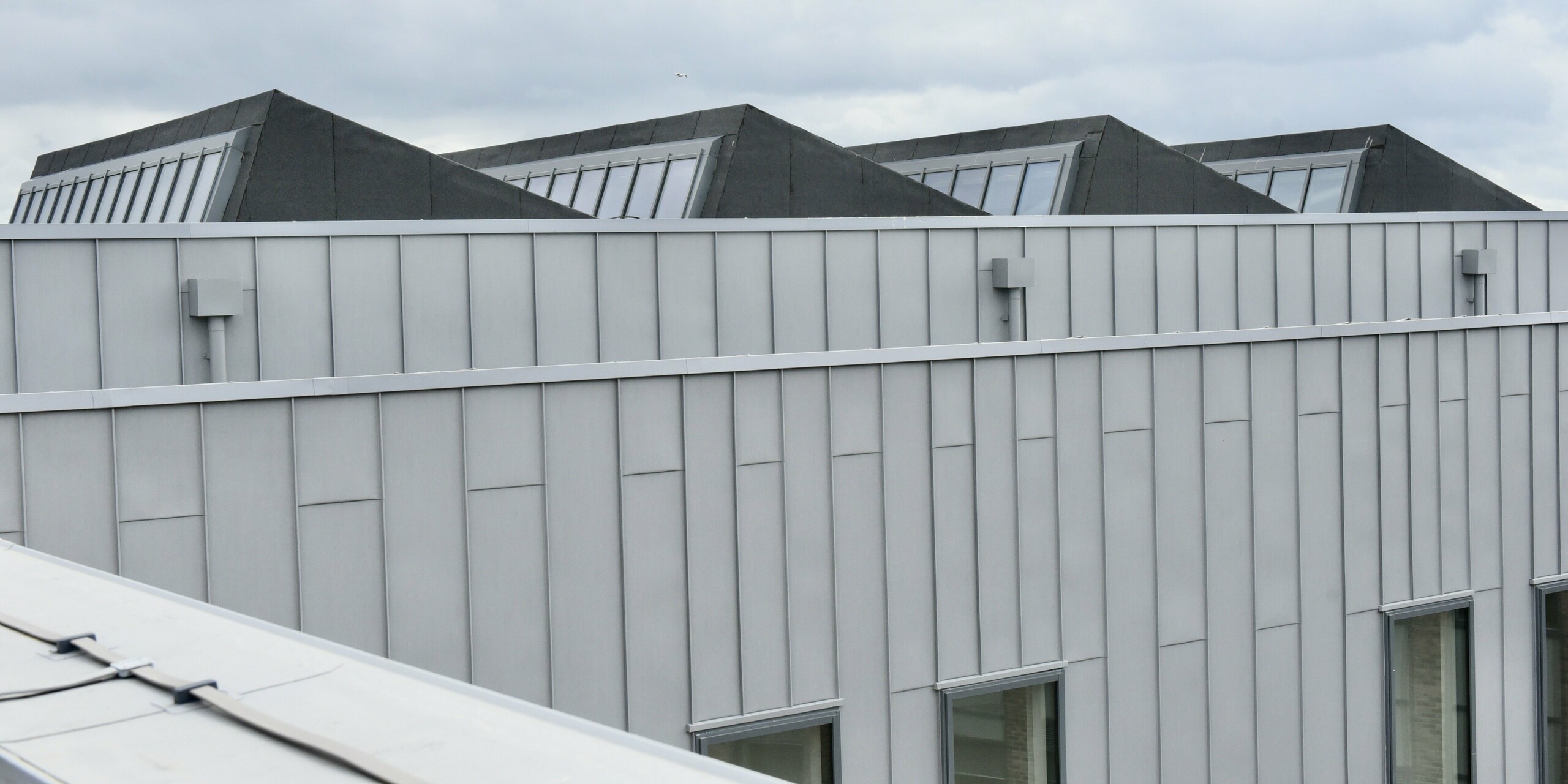 Close-up of the top floor of North Regional College. The patina grey PREFALZ façade highlights the quality of the aluminium cladding and emphasises the building's well-thought-out design.