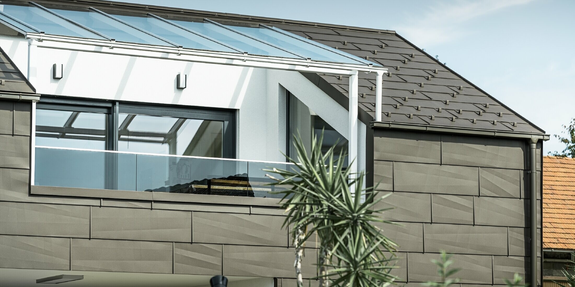 Extension with a roof terrace clad with the PREFA complete system, while the PREFA roof and façade panel FX.12 was used on the roof and façade. In addition, the PREFA box gutter with the PREFA downpipe and the extensive range of accessories in brown are used for roof drainage.