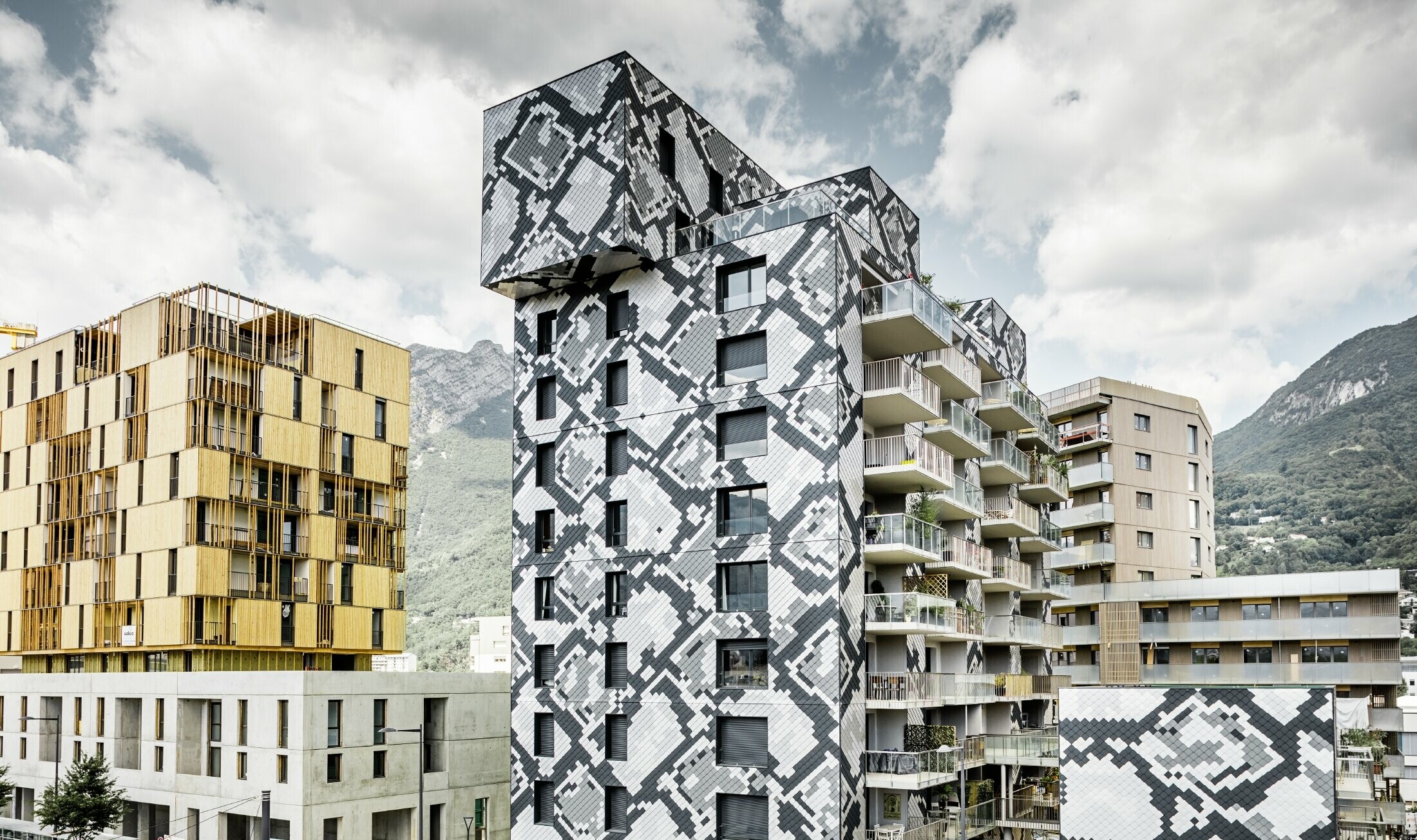 Impressive façade design on the Le Python residential building with a snake pattern. The façade was created using the PREFA rhomboid façade tiles in anthracite, light grey, plain aluminium and metallic silver.