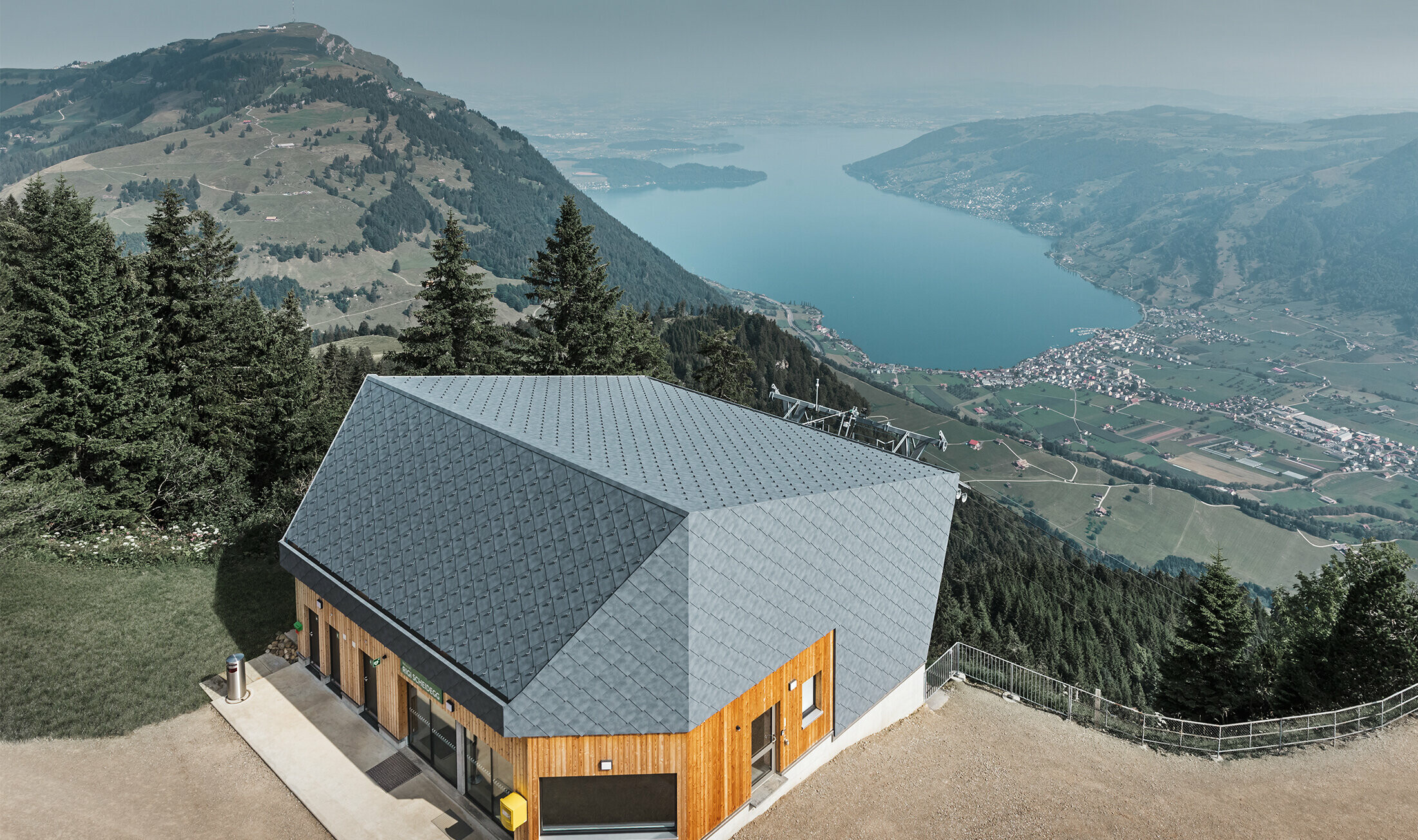 Aerial view of the Rigi Scheidegg cable car mountain station clad in the PREFA 44 x 44 rhomboid façade tile in P.10 stone grey and wood.