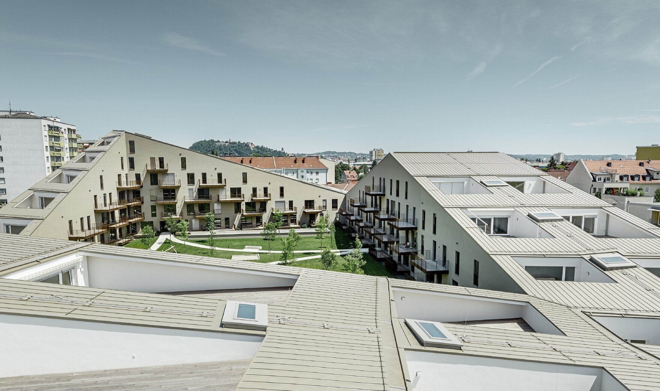 Extended residential complex with a flat roof surface and integrated terraces, generous windows and a Prefalz roof in the special colour of metallic bronze