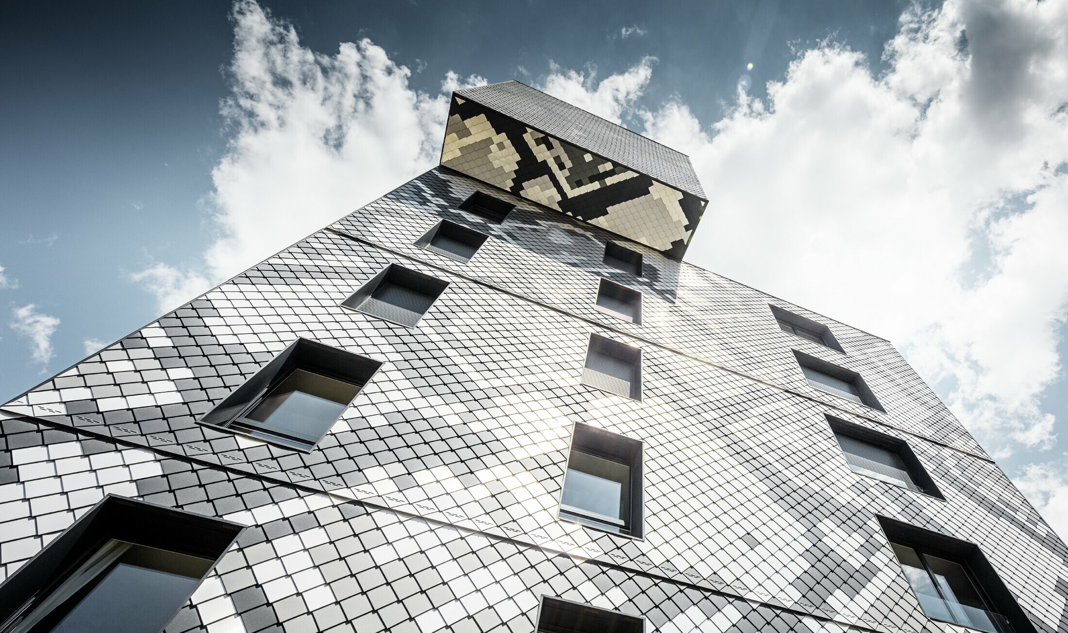 Residential building in Grenoble with the PREFA 20 x 20 rhomboid façade tile in 4 colours; the façade design creates an interesting snake pattern.