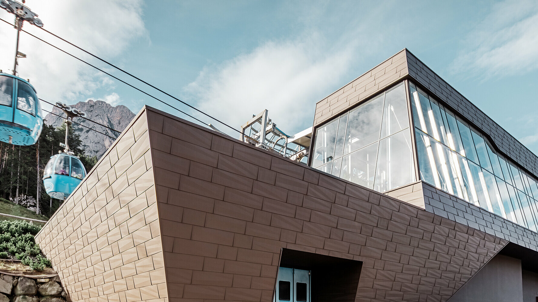 Valley station of a gondola lift in South Tyrol with modern roof and façade cladding from PREFA in brown.