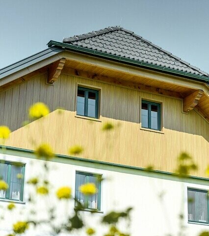 Gable cladding with aluminium panels from PREFA in a natural oak finish; the sidings are installed vertically including the soffit cladding