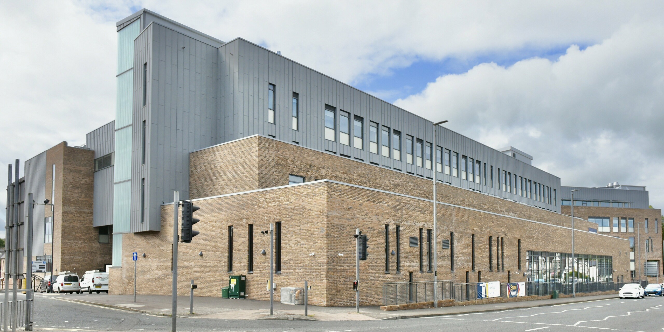 View of the access area to the North Regional College in Coleraine. The PREFALZ aluminium façade in patina grey provides a modern contrast to the historic brick architecture and offers long-lasting durability and elegant design thanks to the standing seam cladding.