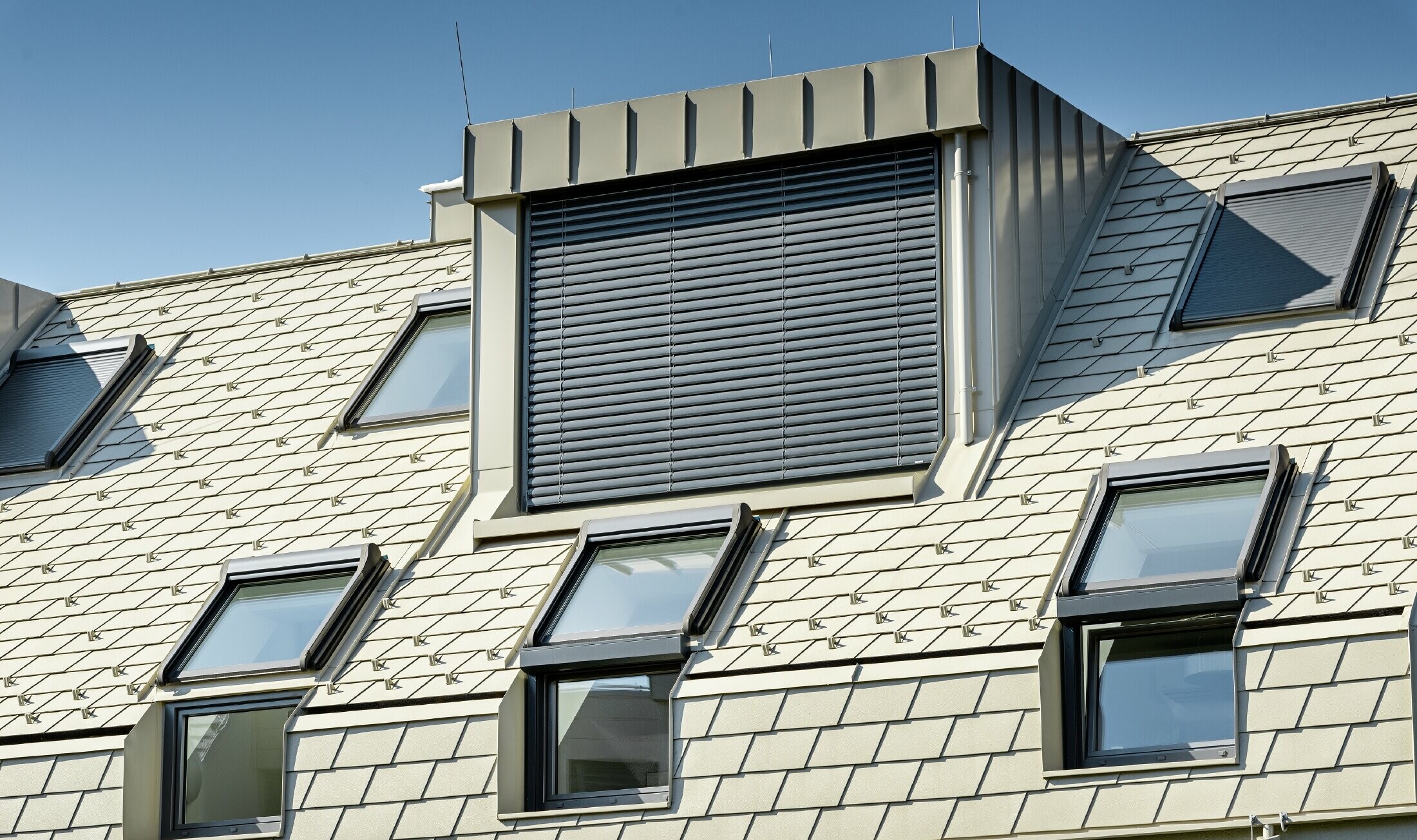 New residential complex with a large aluminium roof surface and a host of roof windows