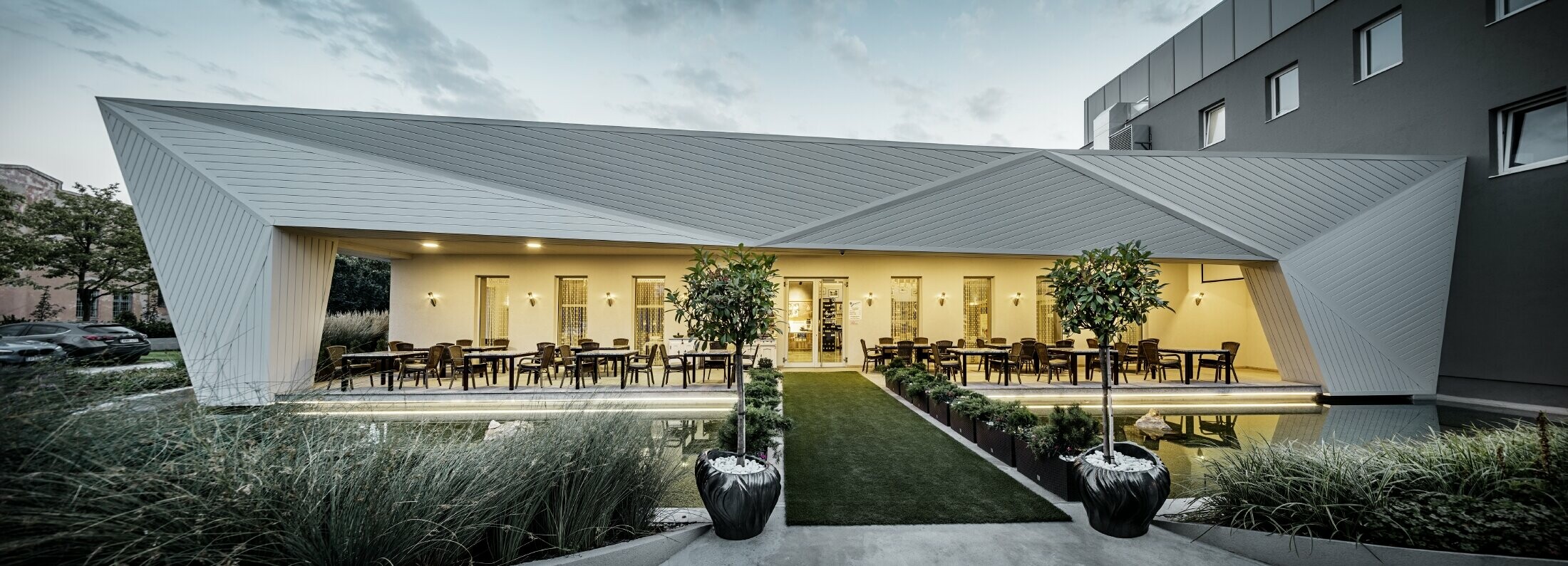 Outdoor dining area of the Mimama restaurant in Budapest, Hungary. The restaurant’s façade is clad in the PREFA sidings in Prefa white.