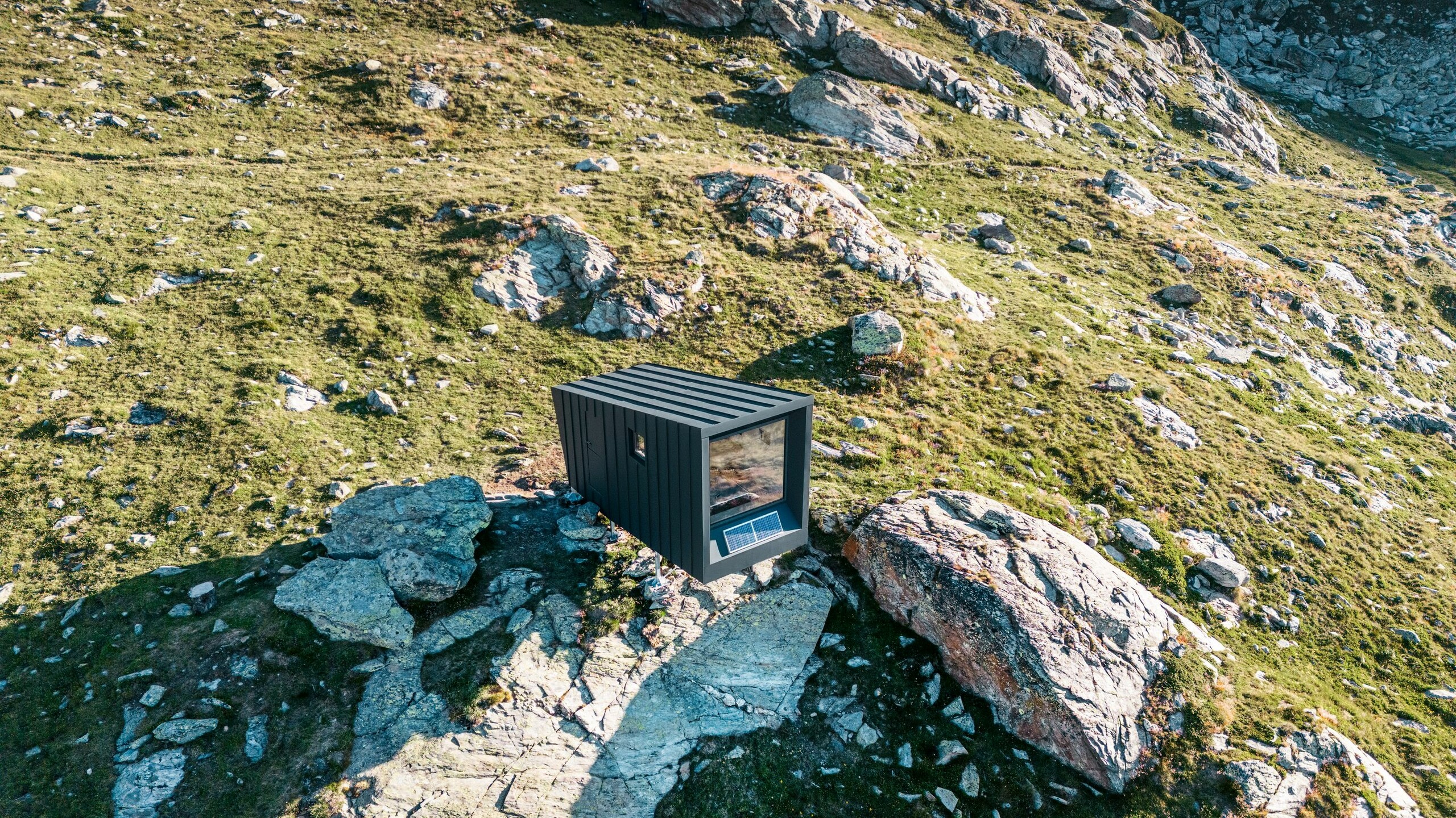 The bivouac from a lateral bird's eye view with the inhospitable nature surrounding it, which is reflected in its front screen.