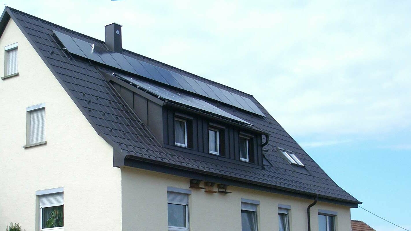 Newly renovated roof with PREFA roof tiles in anthracite; The dormer was clad with Prefalz. There is a photovoltaic system on the roof.