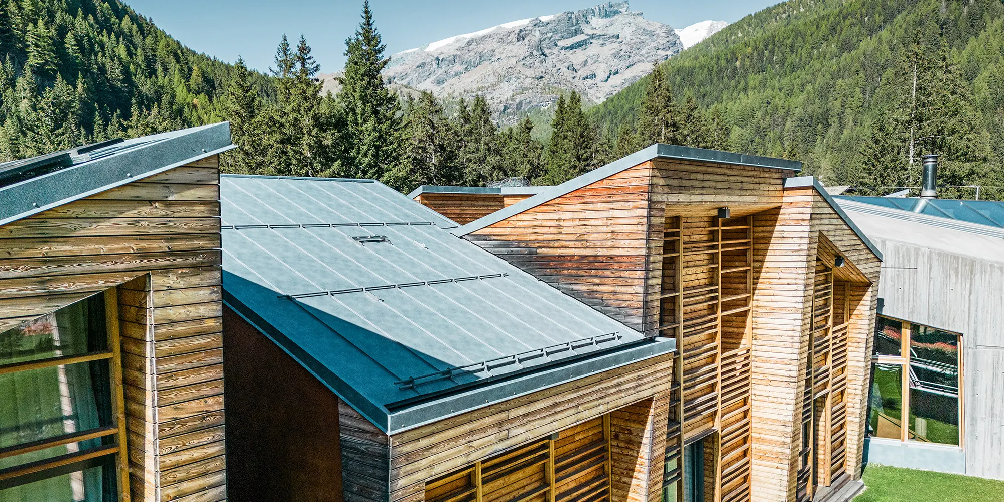 Lateral detail view of the roofscape, the wooden façade and the carefully laid Prefalz sheets are clearly visible.