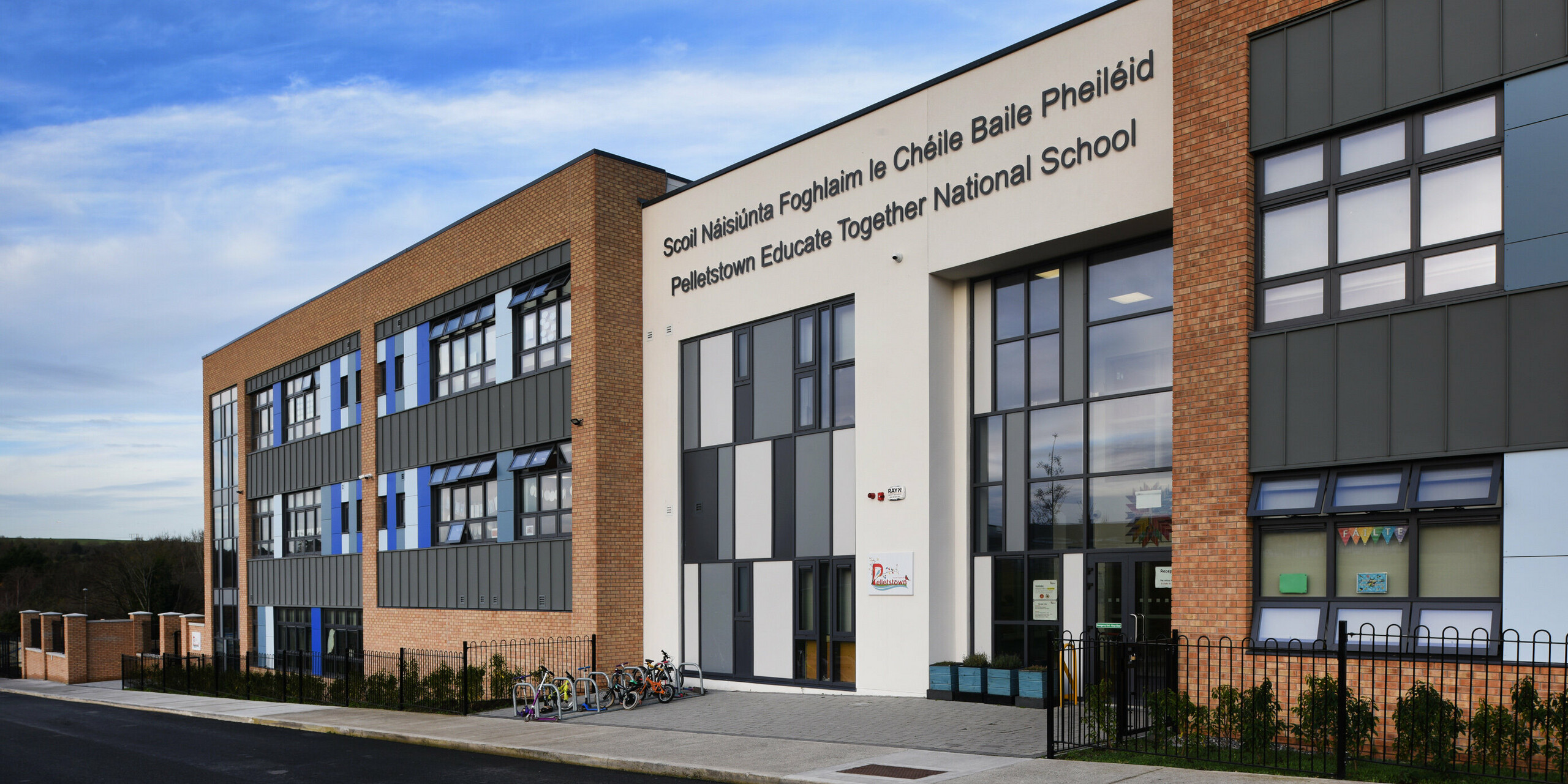 Close-up of the main entrance to Pelletstown Educate Together National School in Dublin. The aluminium façade made of PREFALZ P.10 light grey in combination with plaster and brick creates a unique appearance and provides the school with a durable and aesthetic building envelope.