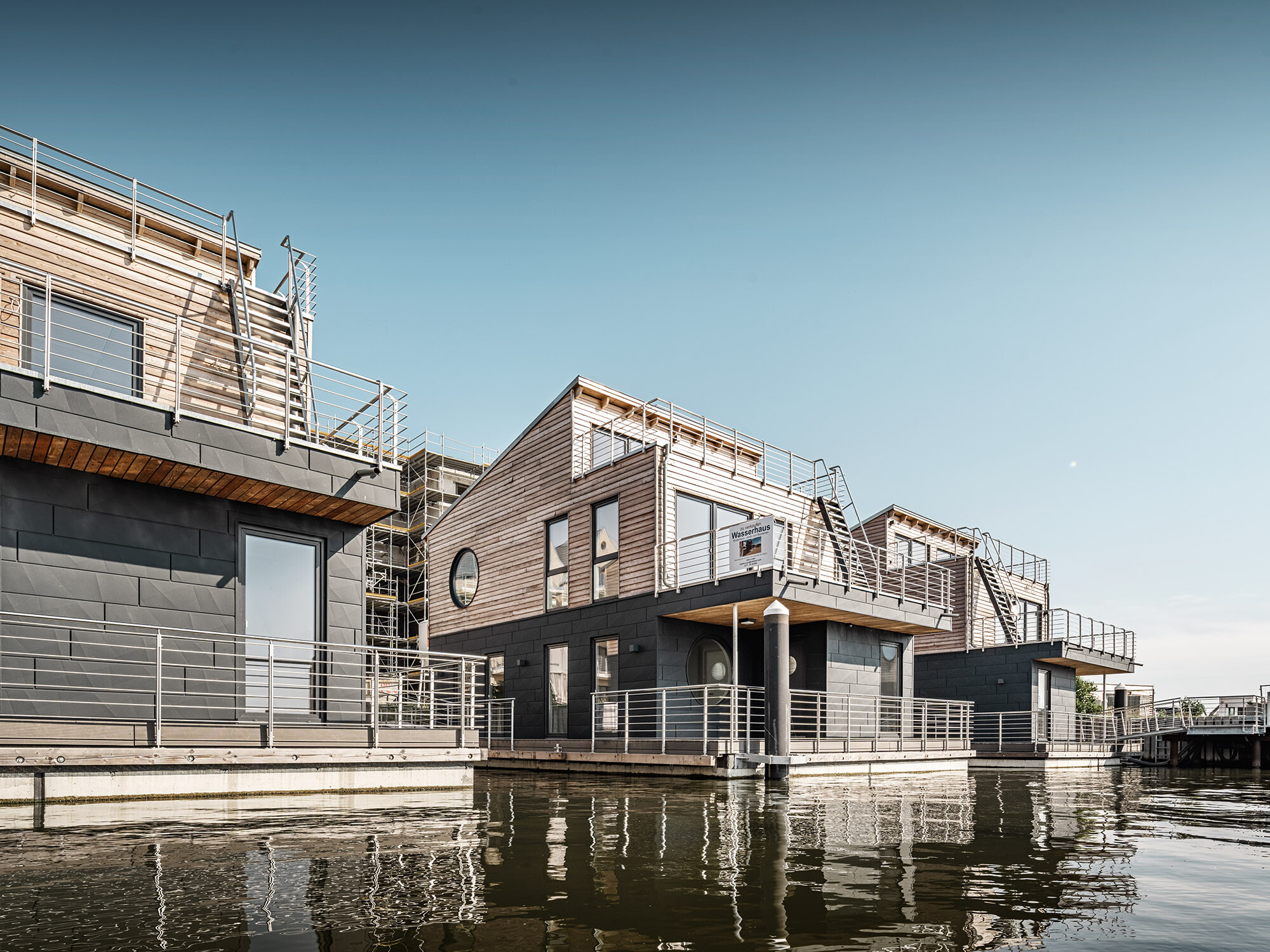 The water houses in Schleswig from a worm's eye view; they are visually divided through their timber and aluminium façades.