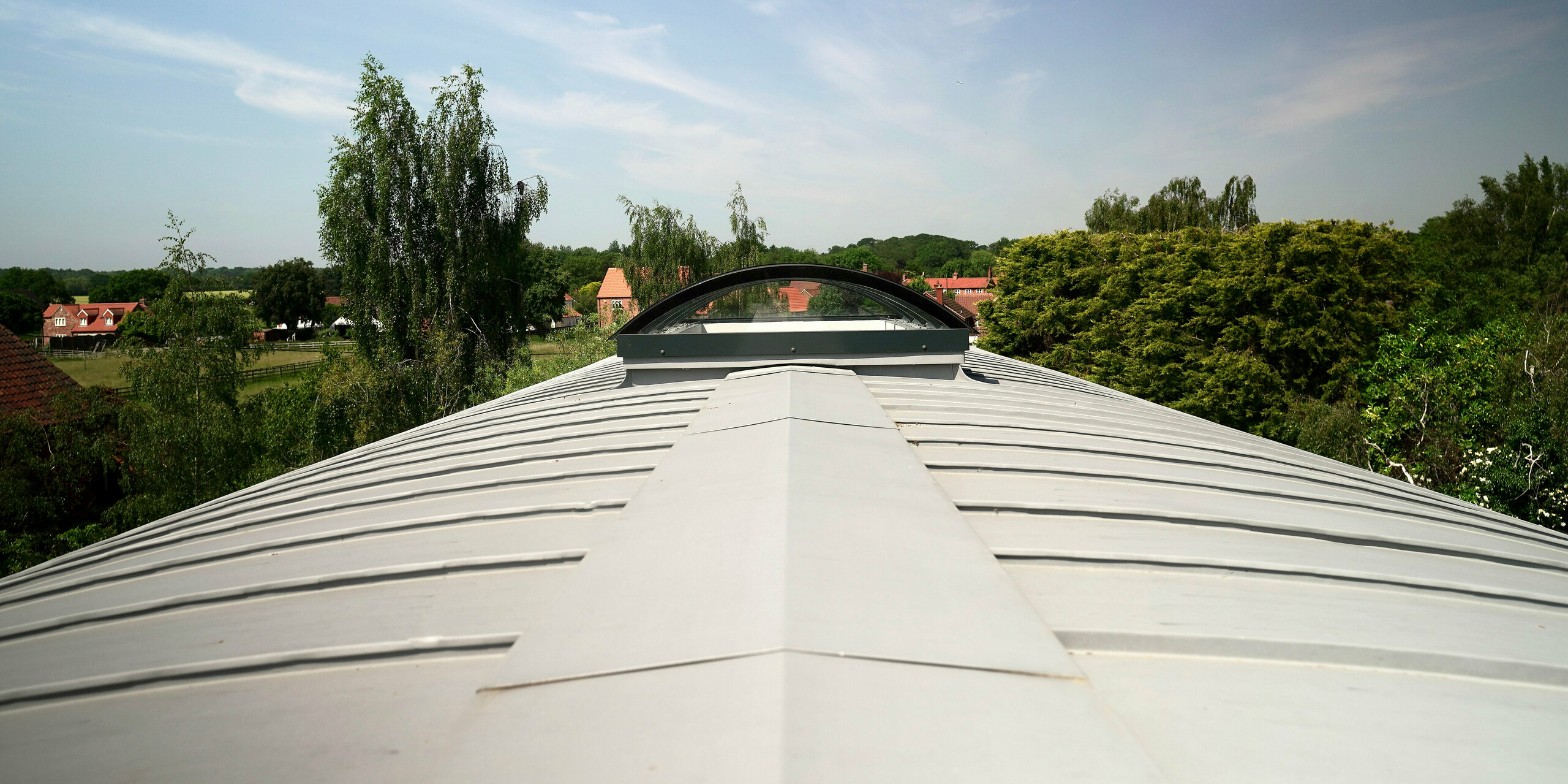 Photo on the roof of a Dutch barn covered with PREFALZ in patina grey