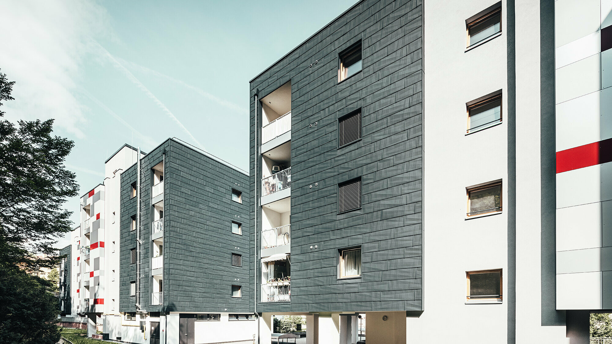 Slightly slanted aerial view of three apartment blocks.