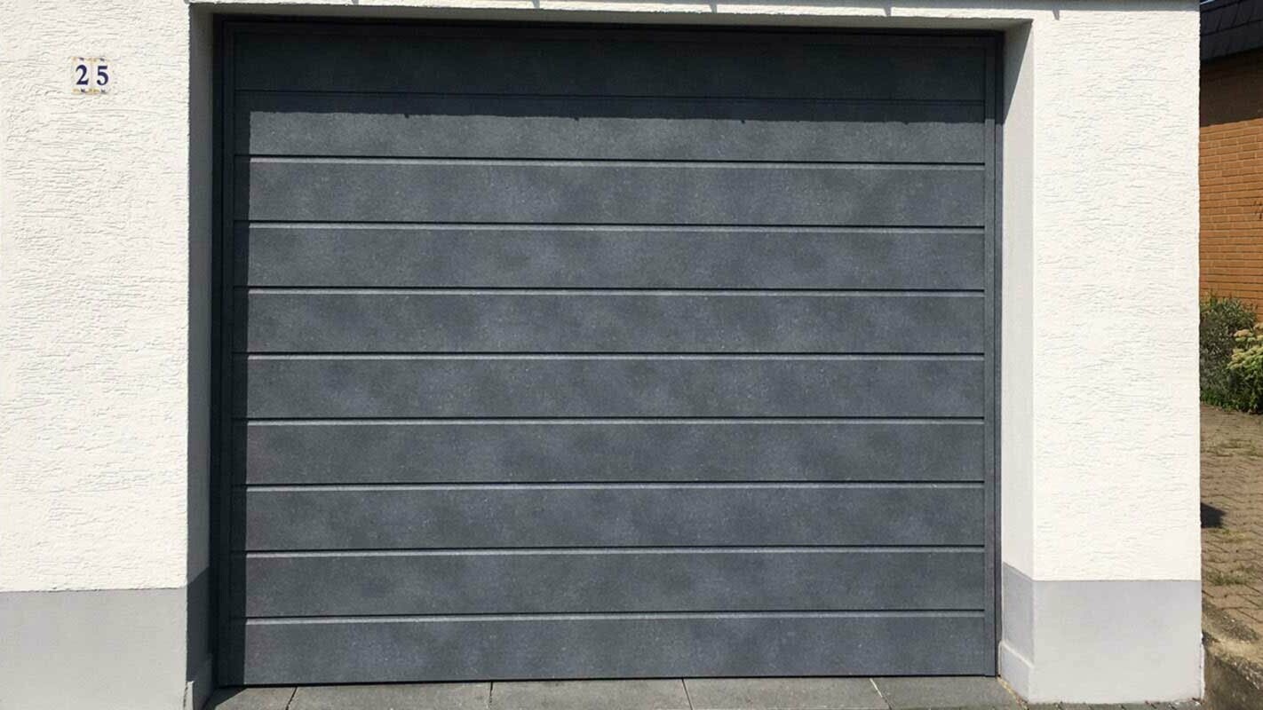 Garage door clad with PREFA sidings in stone grey, installed horizontally