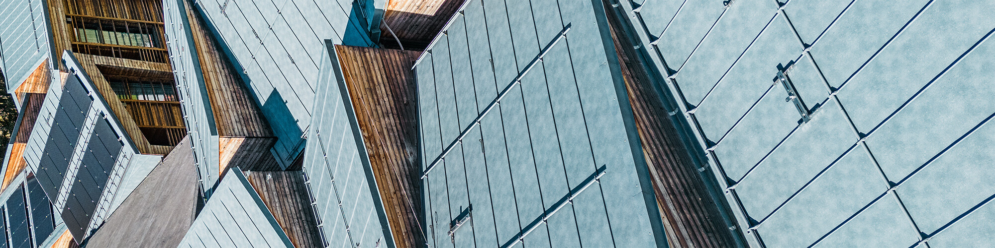 Detail view of the stone-grey, cubist-looking roofscape, the roofs look like they are interlocked.