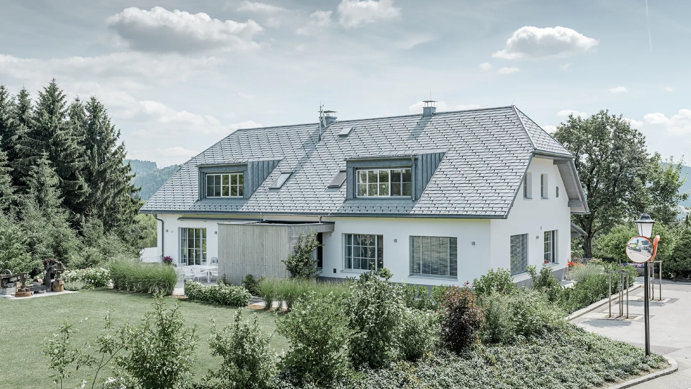 Refurbishment of a half hipped roof with the light PREFA roof shingles in stone grey with two dormers.