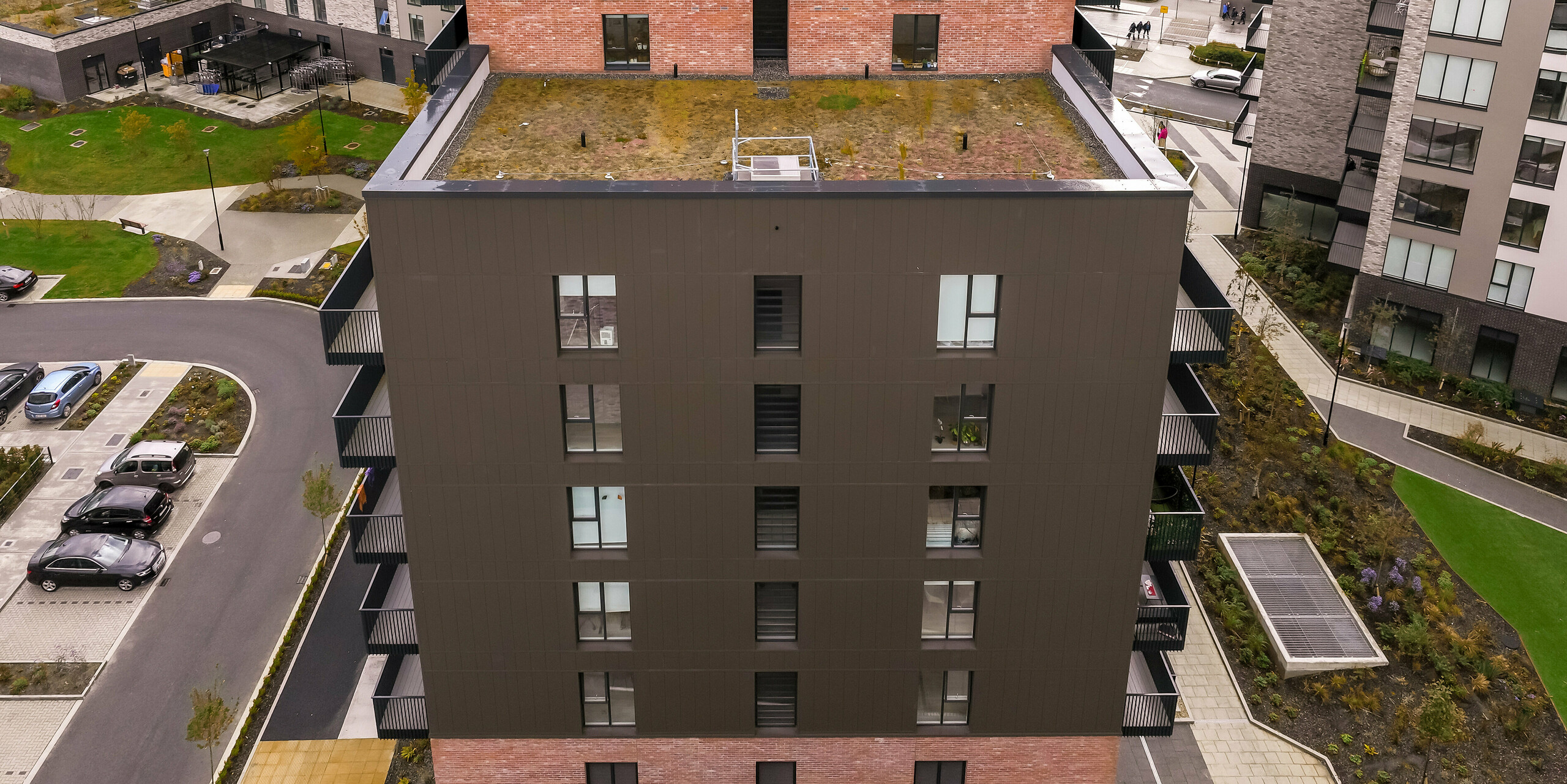 Side view of the Citywest Apartments in Dublin. The vertically laid PREFA sidings in P.10 Brown on approx. 700 m² complement the traditional brick façade. Modern architecture and a durable aluminium façade combine attractive design with weather resistance.